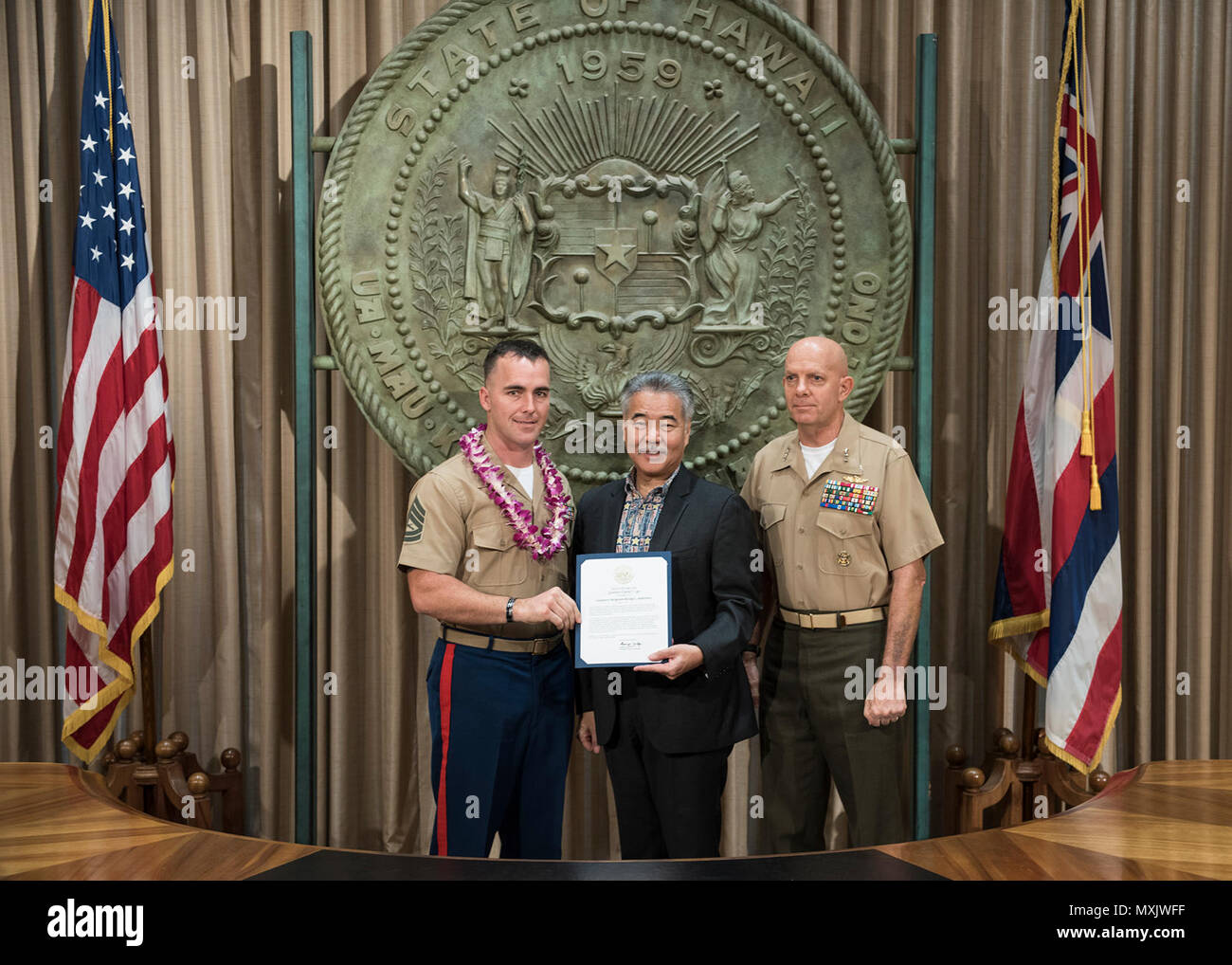 HONOLULU (5 maggio 2017) - Governatore delle Hawaii David Ige, presenta un certificato di apprezzamento a Gunnery Sgt. Kraig Andrews per il suo contributo alle comunità locali. Ige ha pubblicato una proclamazione identificazione di maggio 2017 come militari delle Hawaii apprezzamento mese per riconoscere le Hawaii a base di organi militari. Foto Stock