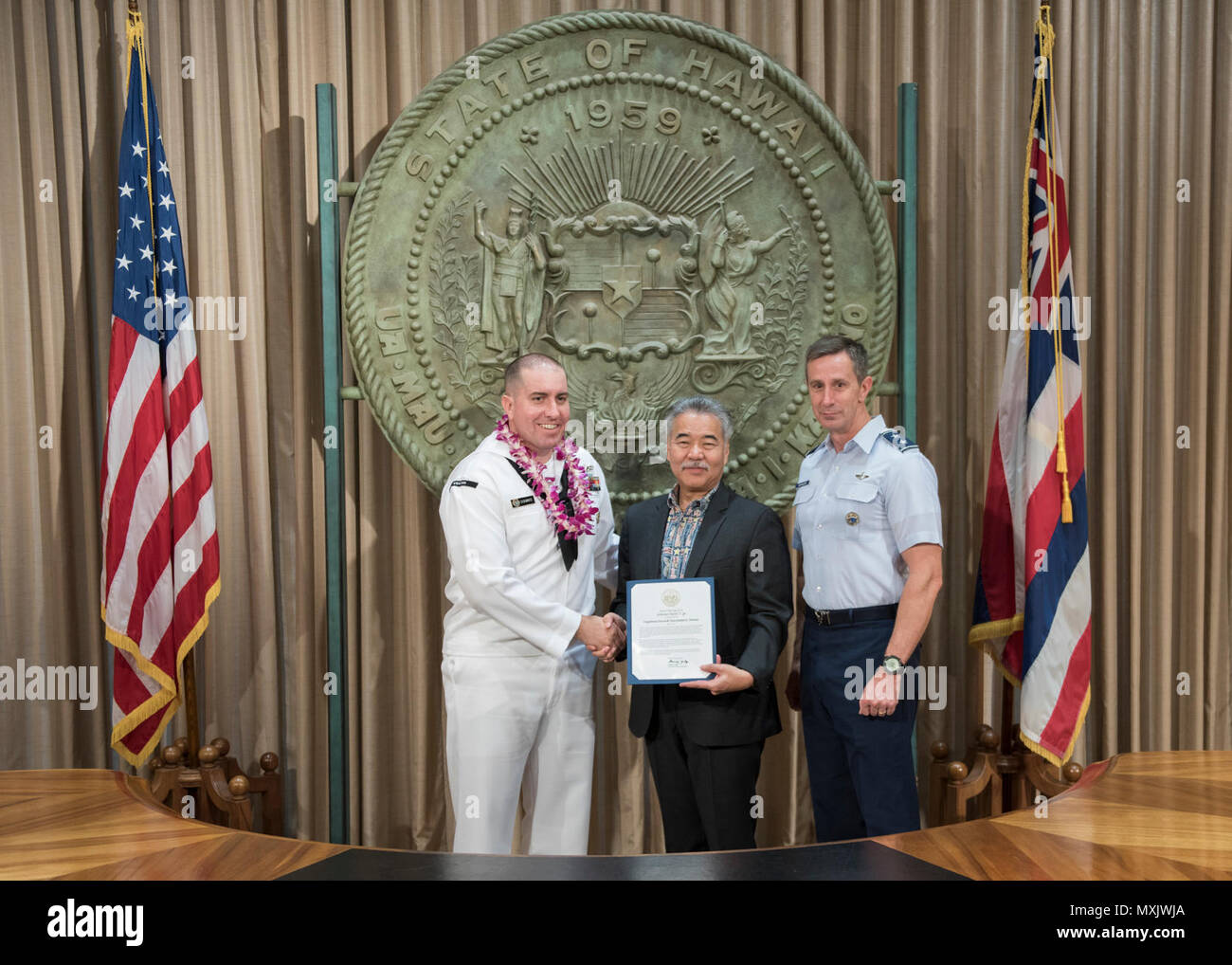 HONOLULU (5 maggio 2017) - Governatore delle Hawaii David Ige, presenta un certificato di apprezzamento a Legalman 2a classe James Downs per i suoi contributi alle comunità locali. Ige ha pubblicato una proclamazione identificazione di maggio 2017 come militari delle Hawaii apprezzamento mese per riconoscere le Hawaii a base di organi militari. Foto Stock