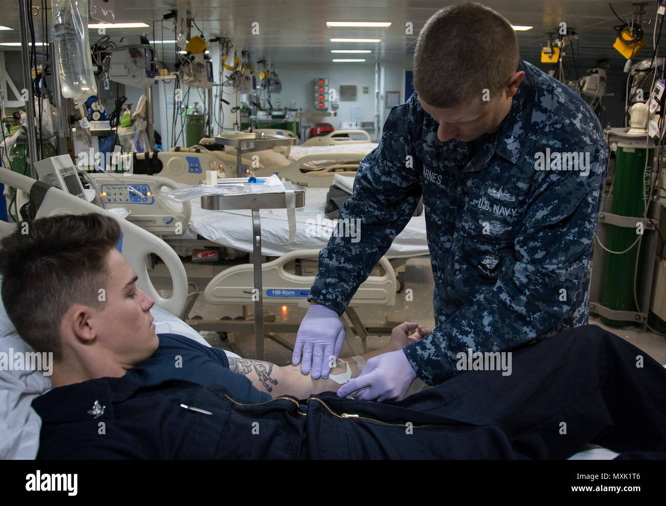 161115-N-WF272-287 Sasebo, Giappone (nov. 15, 2016) Petty Officer 1. Classe Patrick Barnes, da Panama City, Fla., amministra per via intravenosa (IV) la terapia ad un paziente a bordo di assalto anfibio nave USS Bonhomme Richard (LHD 6). Bonhomme Richard, distribuita a Sasebo, Giappone, serve in avanti per fornire una rapida capacità di risposta in caso di emergenza regionale o calamità naturali. (U.S. Navy foto di Sottufficiali di 2a classe di Diana Quinlan/rilasciato) Foto Stock