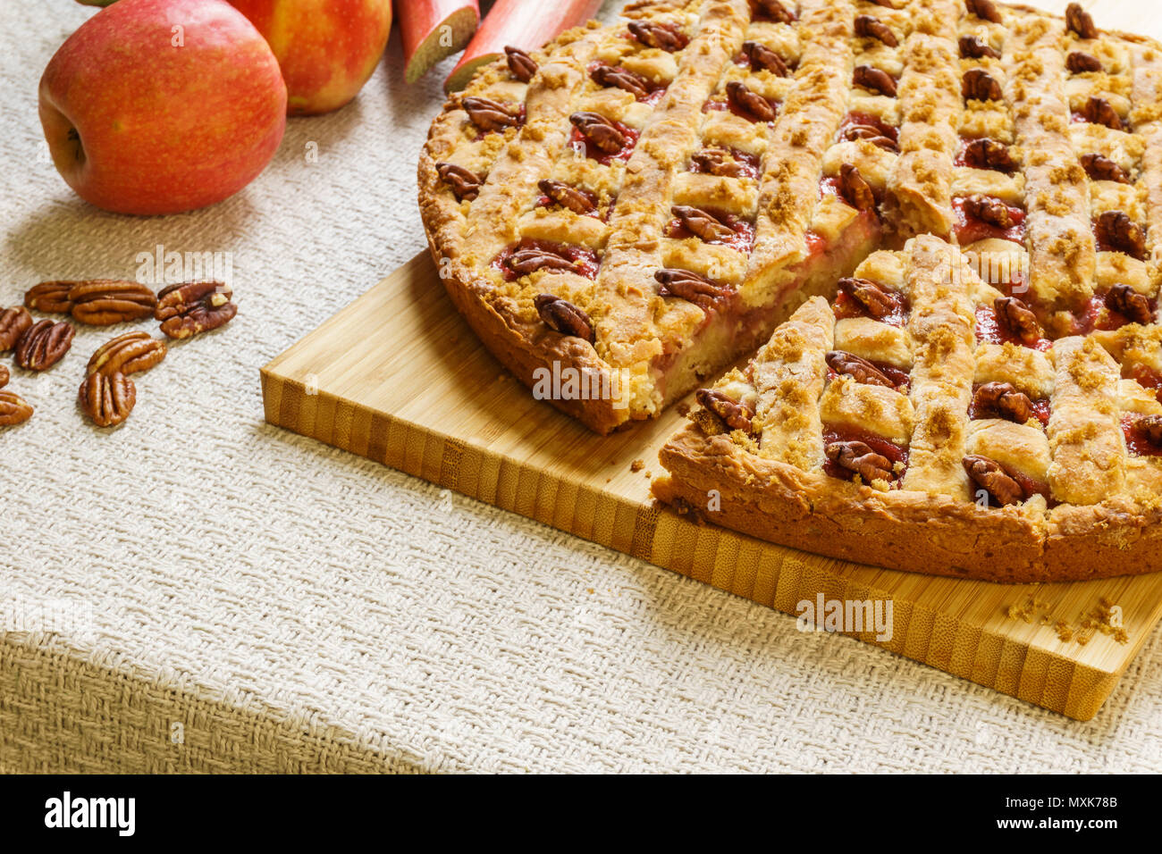 Apple tagliato e Torta al rabarbaro con pecan su un vassoio di nero su un tavolo. Foto Stock