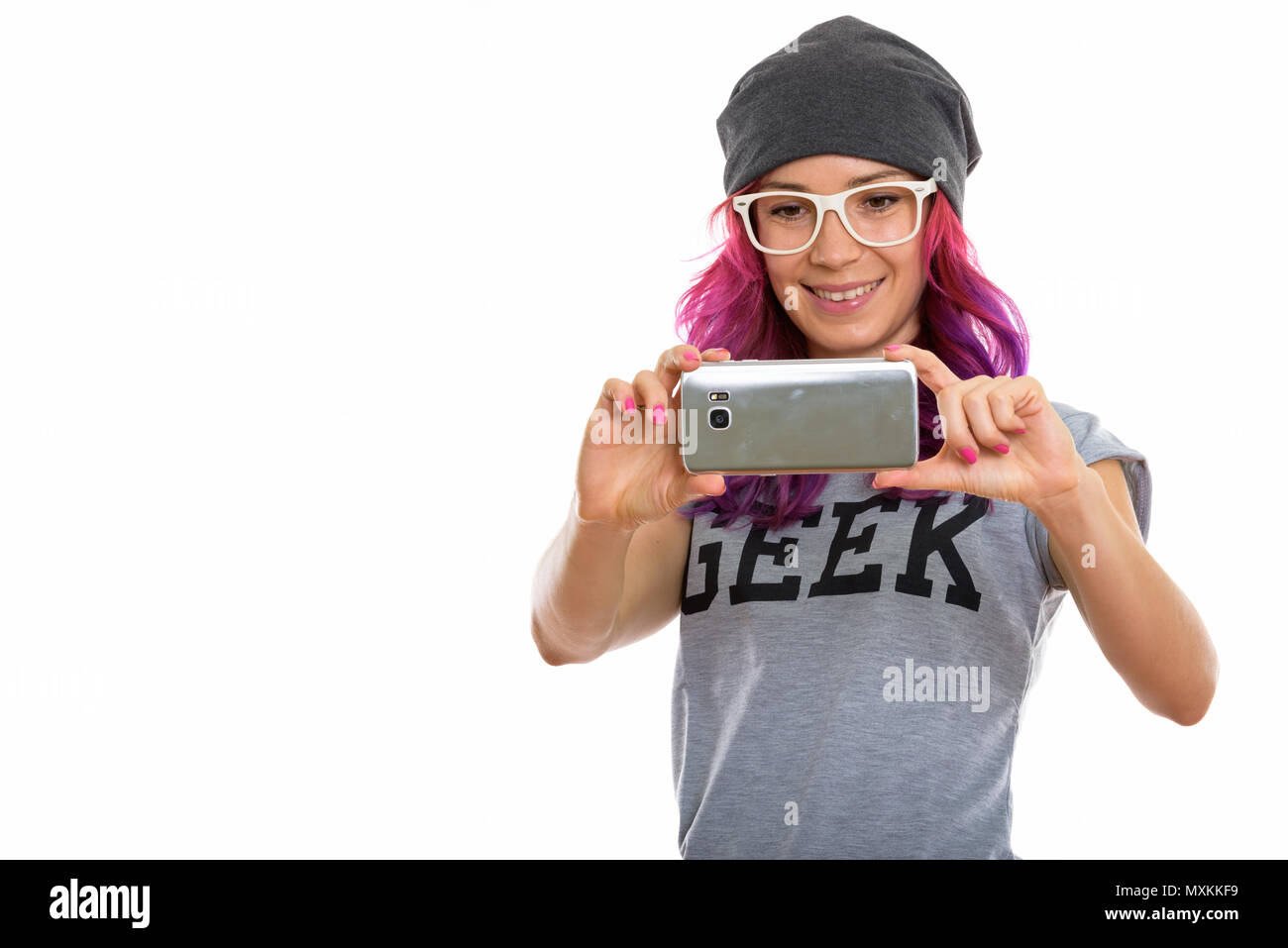 Studio shot di felice geek girl sorridere mentre prendendo foto con Foto Stock