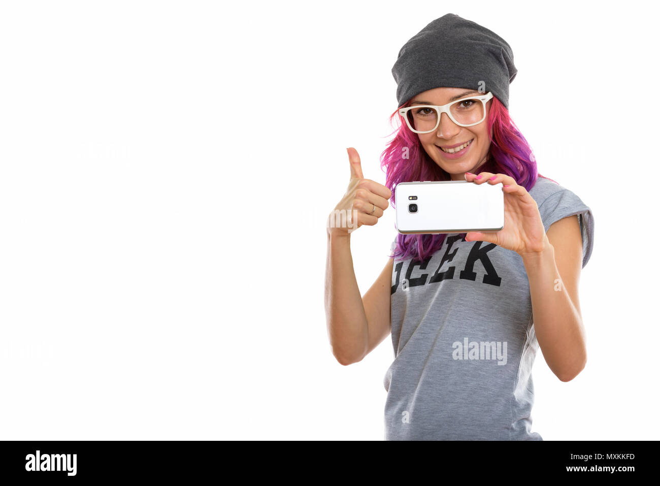 Studio shot di felice geek girl sorridere mentre prendendo foto con Foto Stock