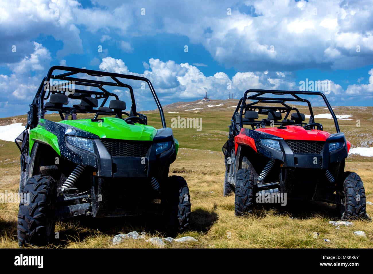 Parcheggiato ATV e UTV, buggy sul picco di montagna con nuvole e cielo blu in background Foto Stock