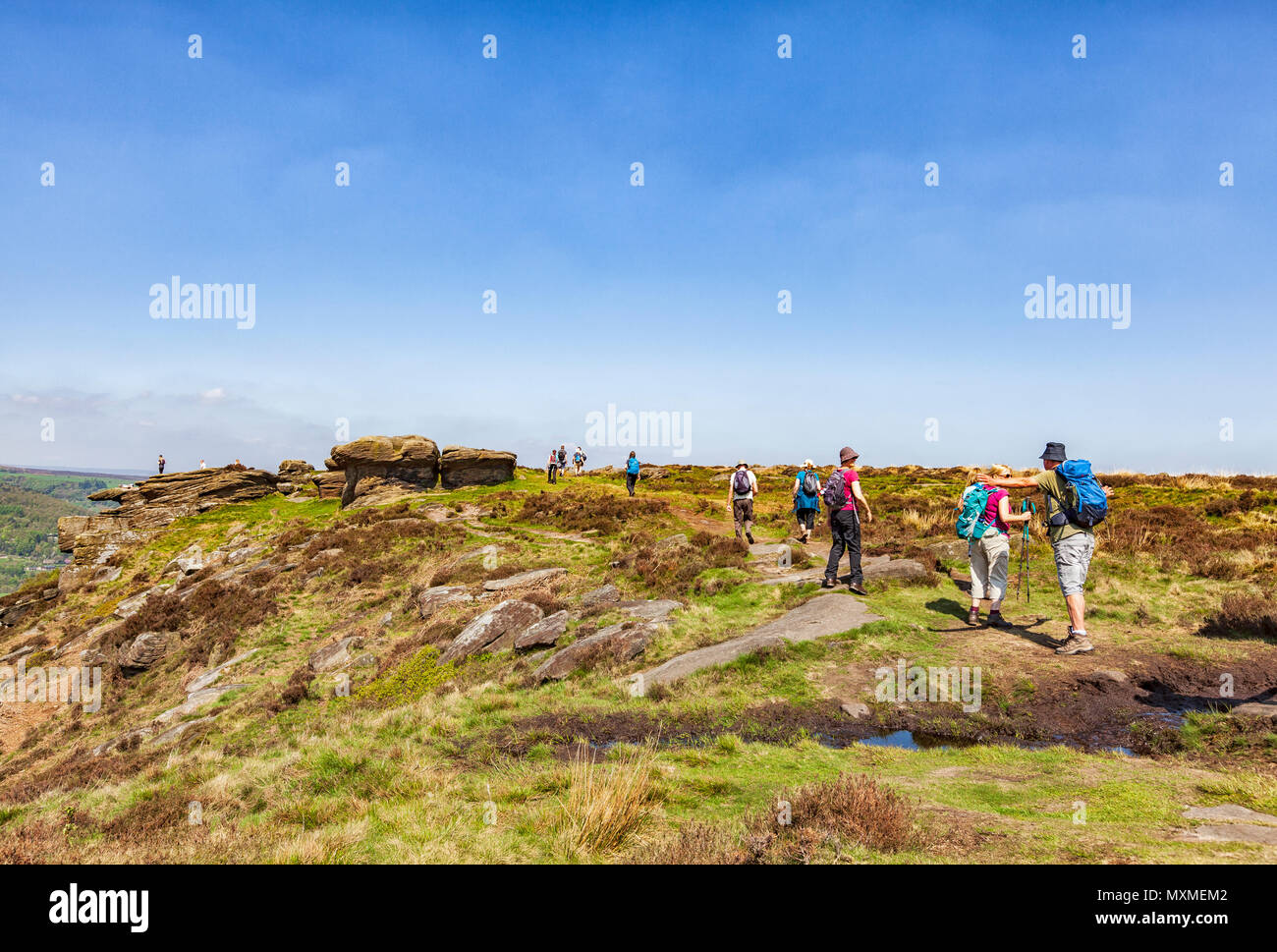 Ramblers camminando sul bordo Curbar, parco nazionale di Peak District, Derbyshire, in Inghilterra, Maggio 2018 Foto Stock