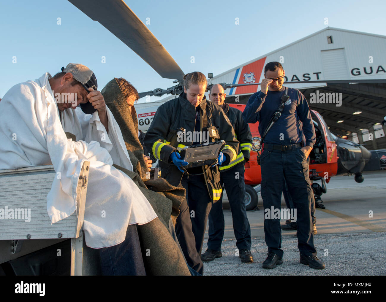 I membri dell'equipaggio da San Pietroburgo, Florida Fire Department valutare tre pescatori che sono stati liberati da un relitto peschereccio a circa 35 miglia a sud-ovest di Capo San Blas, Florida, mercoledì, nov. 23, 2016. I pescatori hanno volato per la guardia costiera Stazione aria Clearwater da un MH-60 elicottero Jayhawk equipaggio dove si sono incontrati con EMS; senza lesioni alla relazione. Stati Uniti Coast Guard foto di Sottufficiali di prima classe Michael De NYSE. Foto Stock