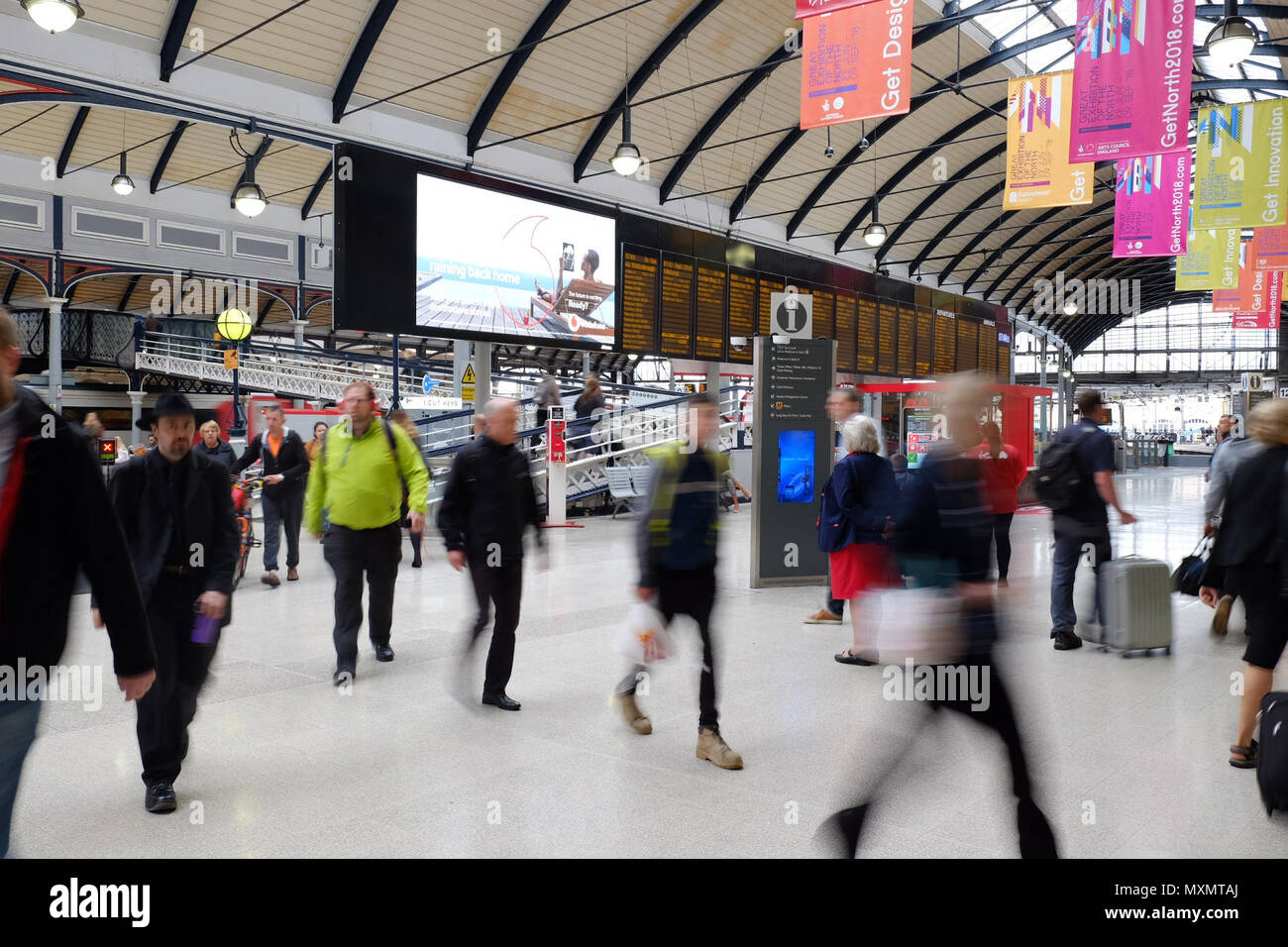 Passeggeri a Newcastle upon Tyne stazione ferroviaria il giorno che l'operatore ferroviario ha introdotto un calendario di emergenza, rimozione 165 treni - 6% dei servizi. tabella Foto Stock