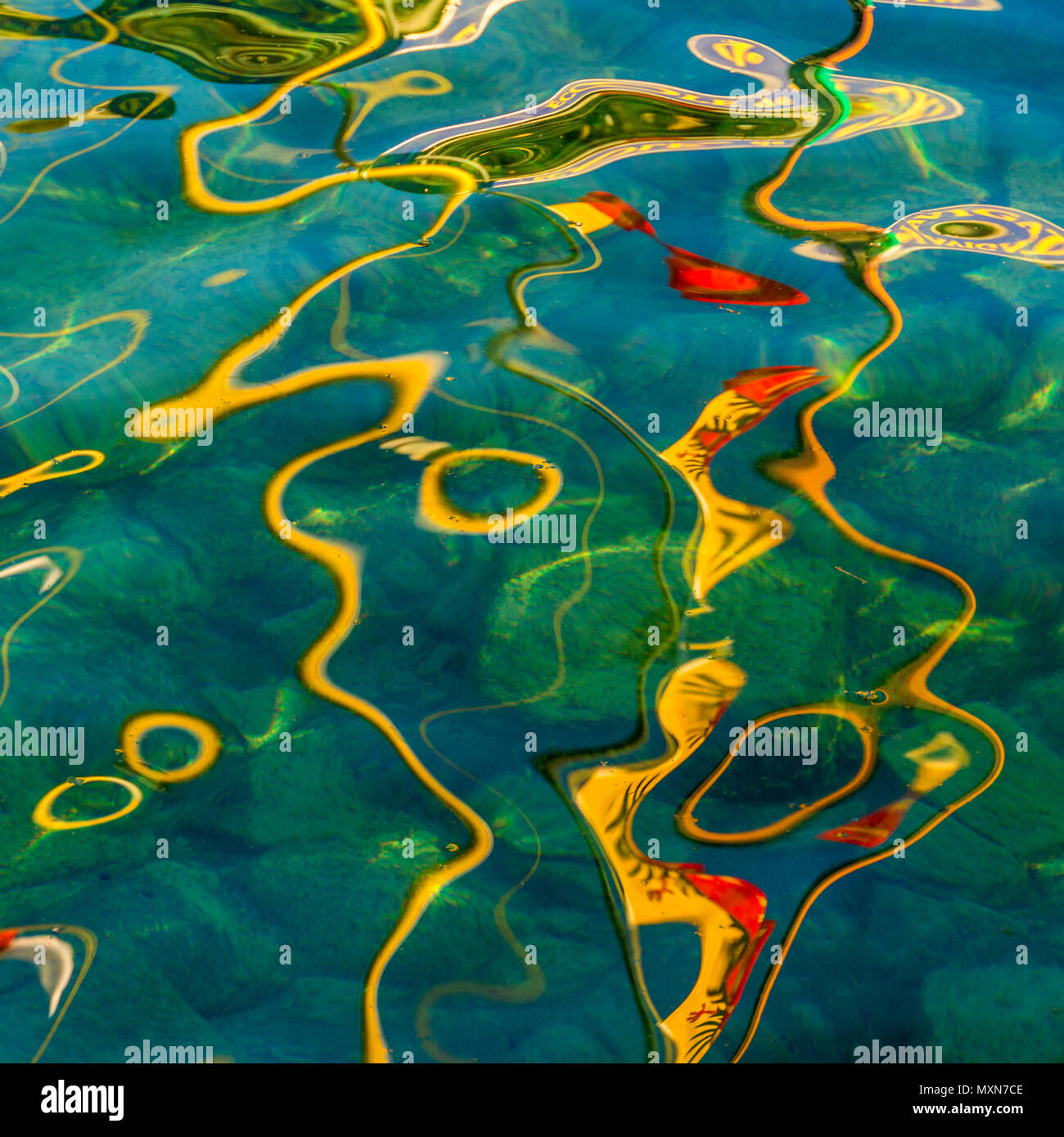 Riflessi colorati sull'acqua con motivi e texture vivaci in un ambiente tranquillo Foto Stock