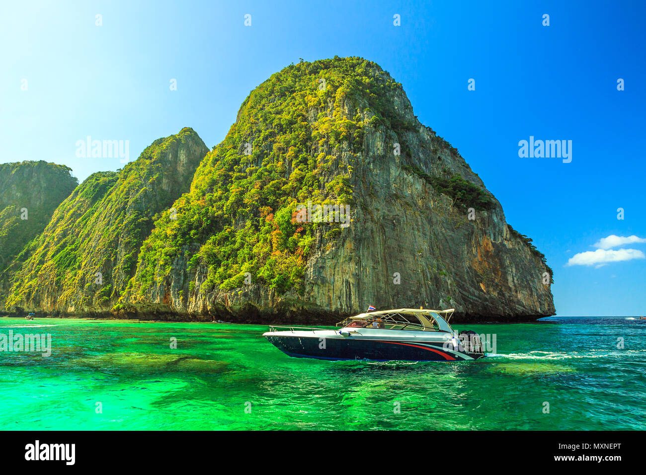 Il motoscafo entra la scenic laguna di popolare Maya Bay spiaggia circondata da ripide colline di pietra calcarea in Ko Phi Phi Leh, Krabi, sul Mare delle Andamane, Thailandia. Famosa attrazione turistica. Durante la stagione estiva, giornata di sole. Foto Stock