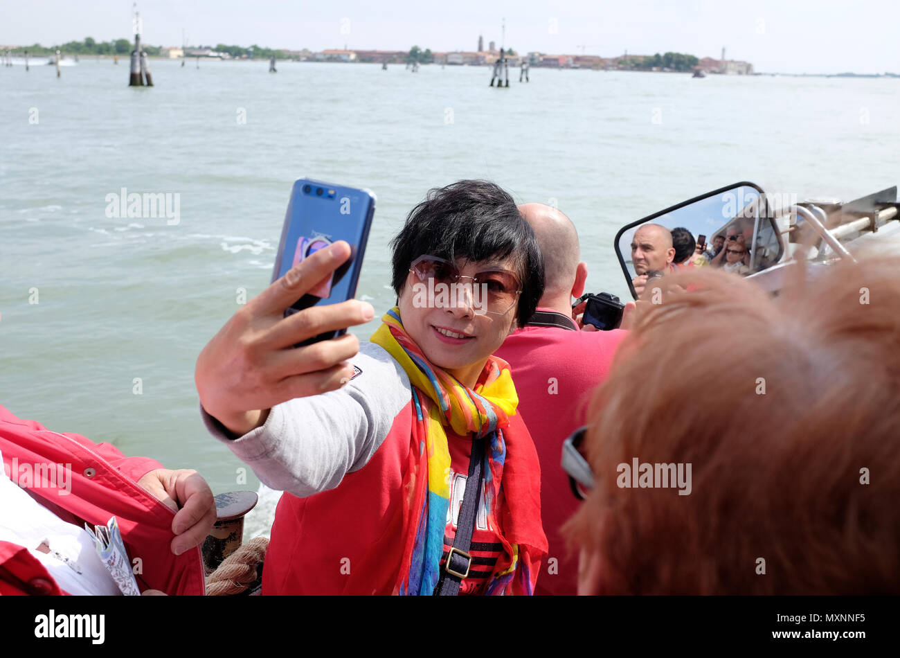Asia femmina turistica prendendo selfie sulla barca a Venezia, Italia Foto Stock
