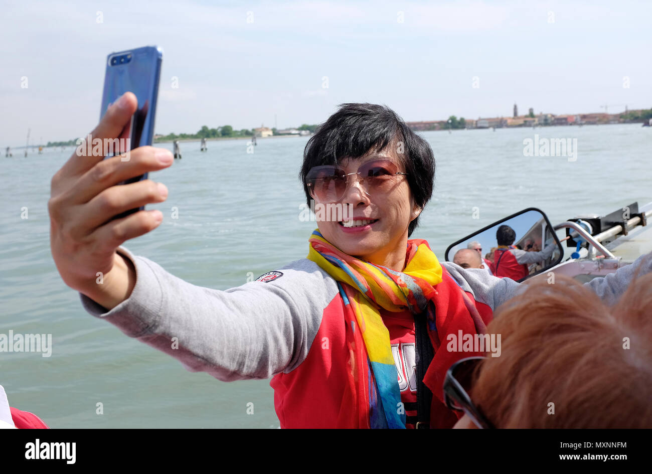 Asia femmina turistica prendendo selfie sulla barca a Venezia, Italia Foto Stock