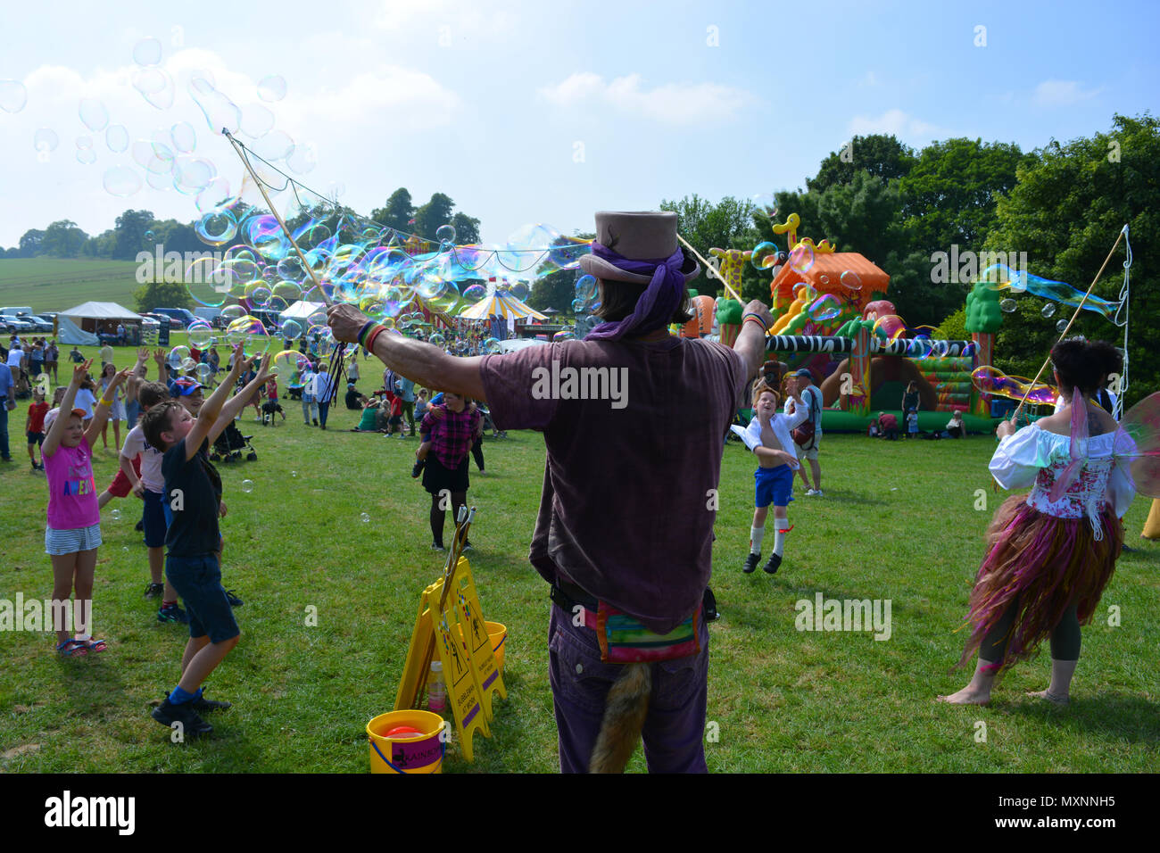 Bubblemania rendendo le bolle di sapone per intrattenere la folla annuale di Sherborne Castle Country Fair, Sherborne, Dorset, Inghilterra. Foto Stock