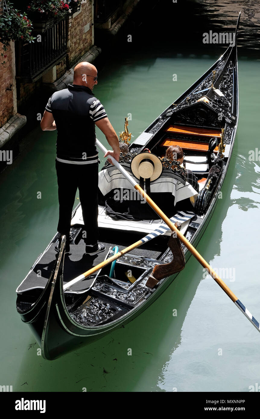 Gondoliere barcaiolo e turisti in gondola a Venezia, Italia Foto Stock