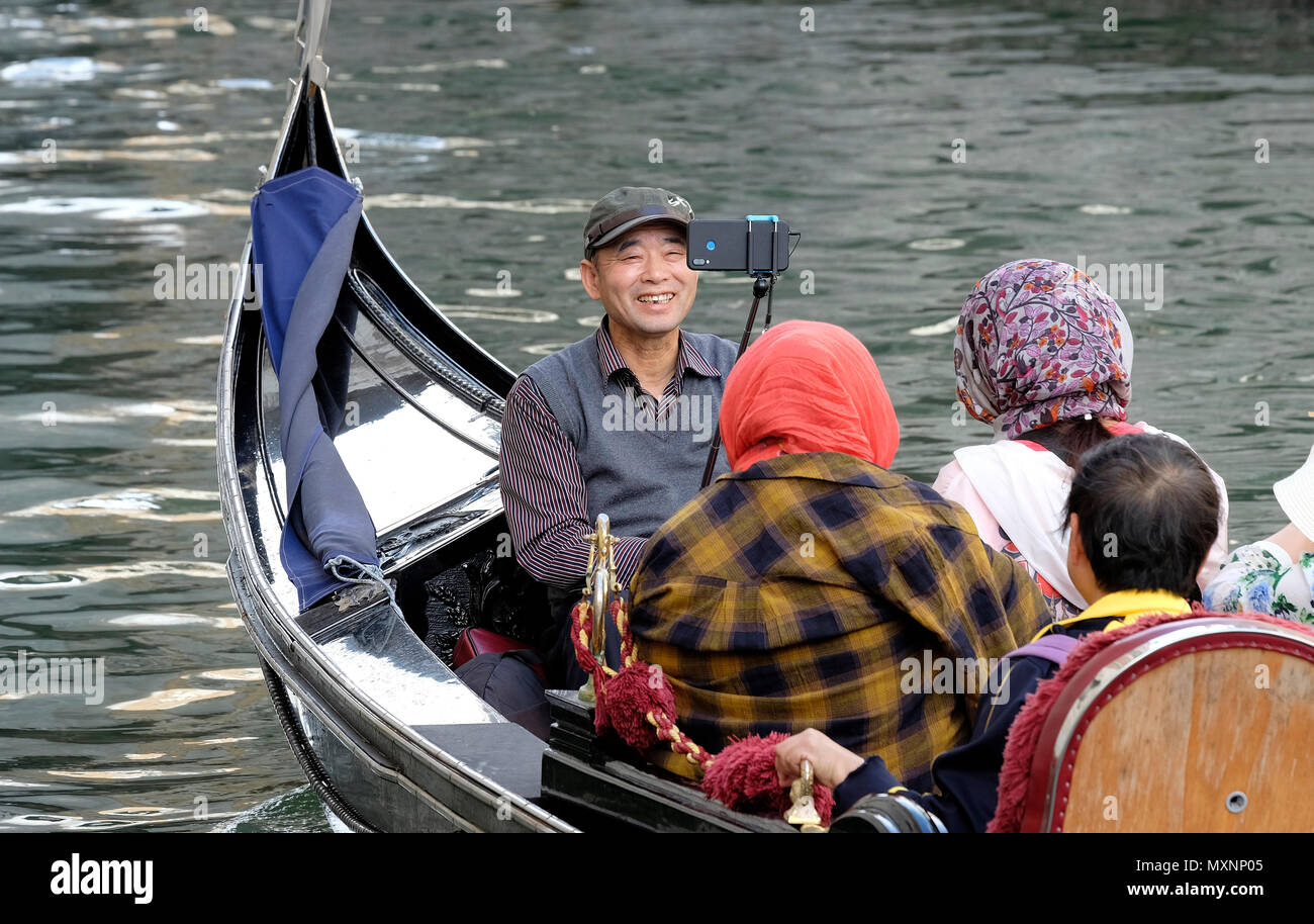 Uomo asiatico tenendo selfie foto sulla gondola a Venezia, Italia Foto Stock