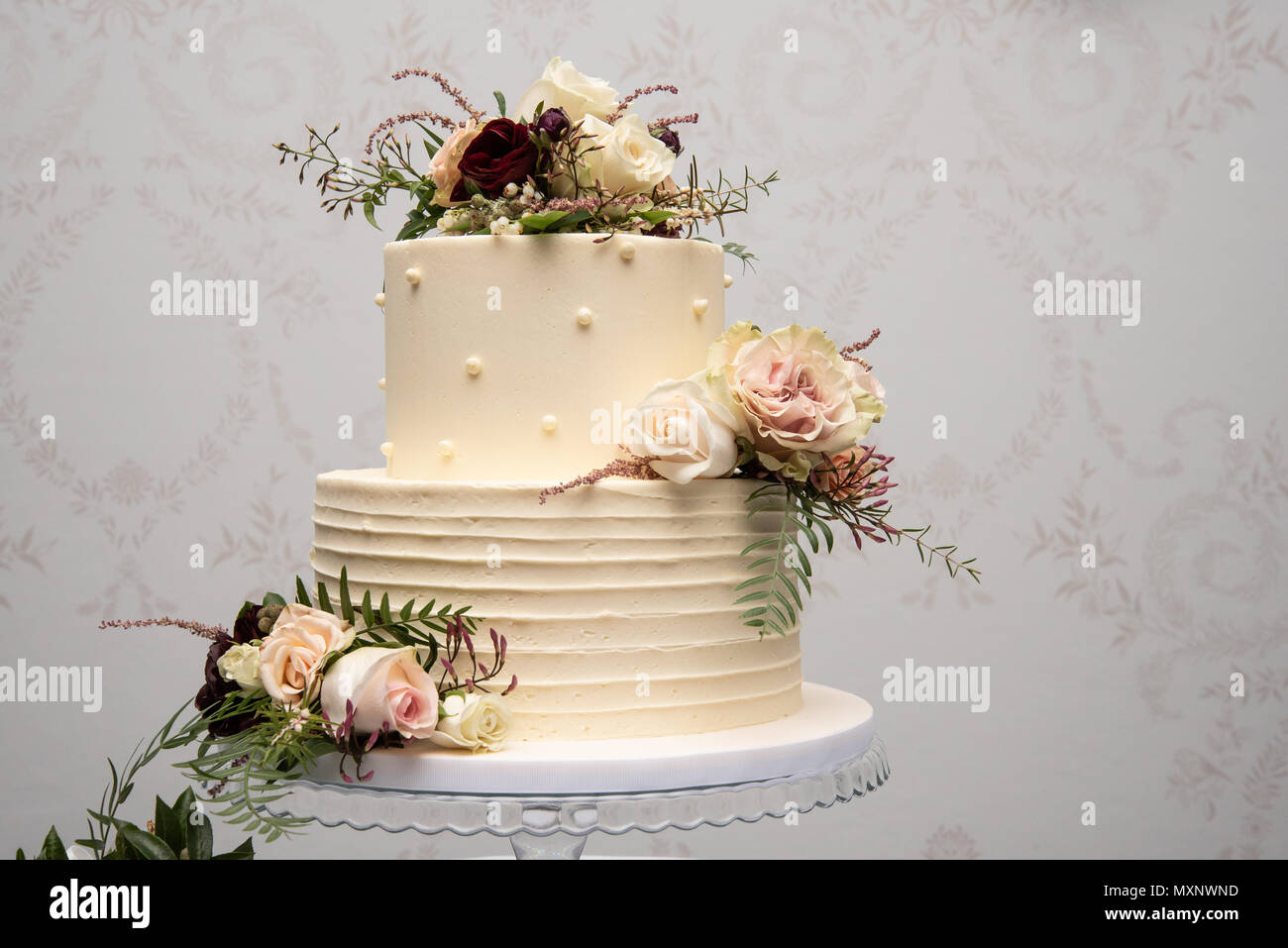 Champagne torta di nozze con giallo e rosa addobbi floreali Foto Stock
