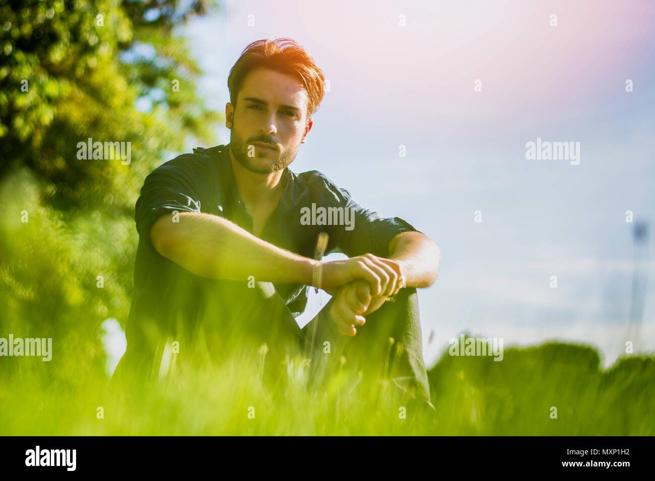 Montare il bel giovane rilassarsi sdraiati su un prato Foto Stock