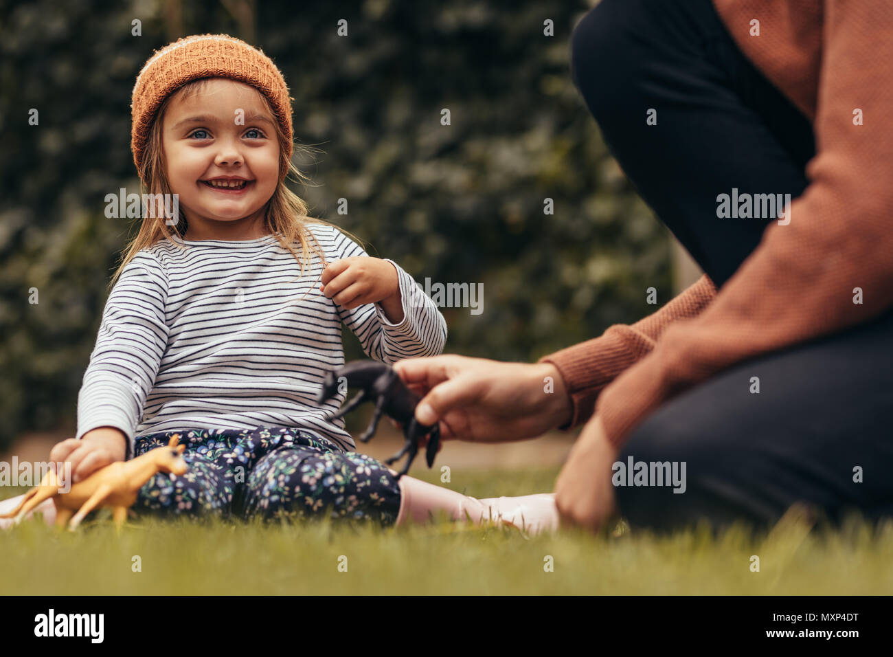 Padre e figlia seduti nel parco e giocare con i giocattoli. Padre e figlia di trascorrere del tempo insieme a un parco. Foto Stock