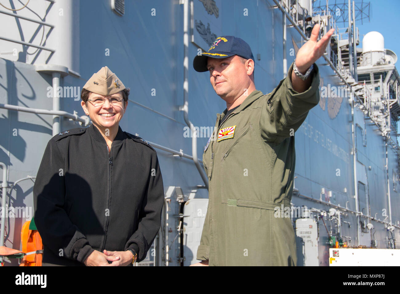 161129-N-TH560-121 Sasebo, Giappone (nov. 29, 2016) della Cmdr. Jason Stumpf (a destra), air boss di assalto anfibio nave USS Bonhomme Richard (LHD 6), descrive Bonhomme Richard del ponte di volo funzionalità a capo dei cappellani Adm posteriore. Margaret Kibben durante una nave's tour. Bonhomme Richard, distribuita a Sasebo, Giappone, serve in avanti per fornire una rapida capacità di risposta in caso di emergenza regionale o calamità naturali. (U.S. Navy foto di Sottufficiali di terza classe Jeanette Mullinax/rilasciato) Foto Stock