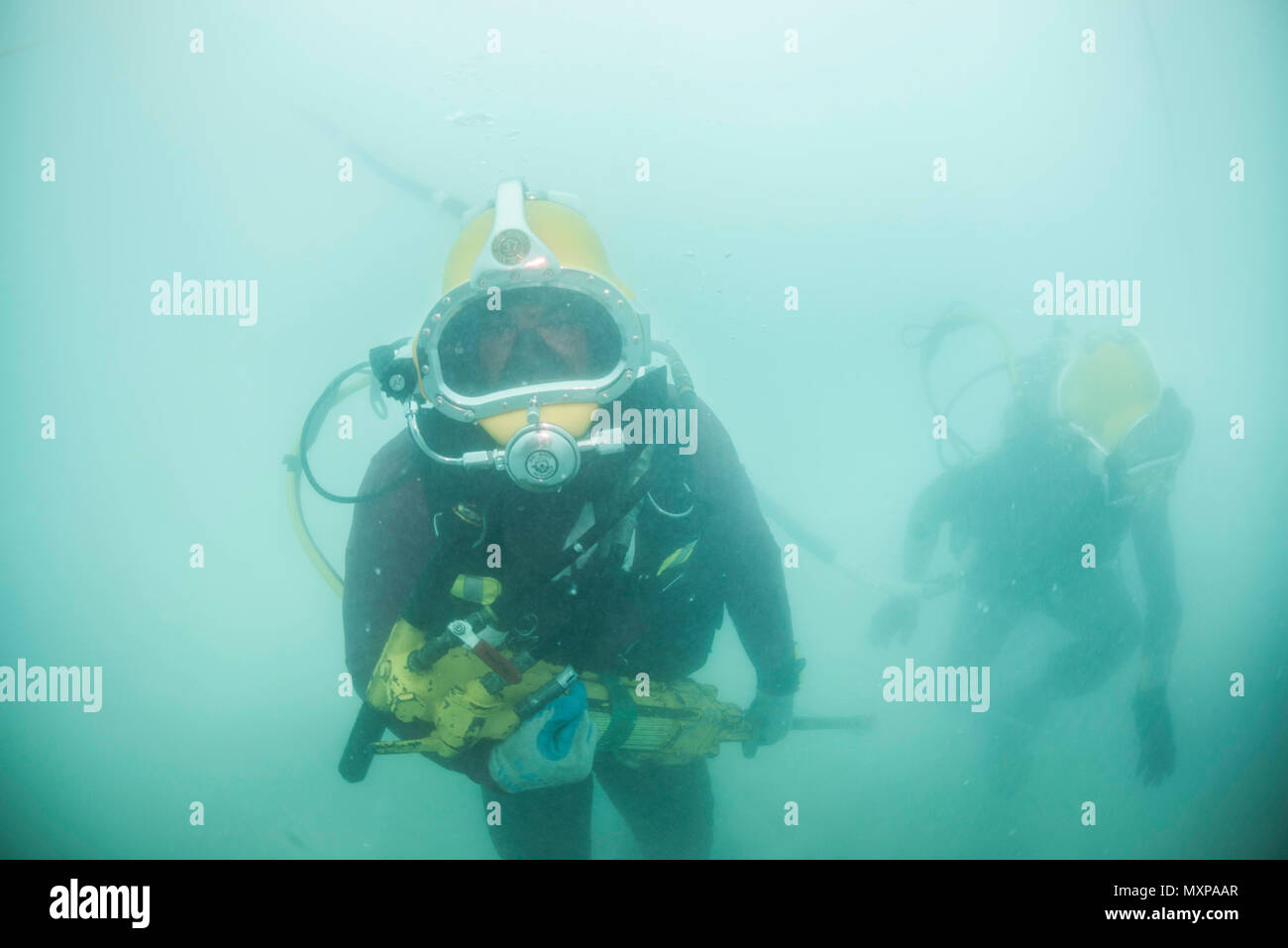 Petty Officer 1. Classe Matt Ramirez, centro, assegnato alla costruzione subacquea Team (UCT) 2's costruzione Dive distacco Bravo (CDDB), si sposta un attrezzo idraulico ad un sito di lavoro in Diego Garcia, Territorio britannico dell'Oceano Indiano, su nov. 14, 2016. CDDB è di eseguire la precisione demolizioni subacquee e recupero per rimuovere ostruzioni da Diego Garcia profonde del progetto wharf. CDDB è il terzo stop della loro distribuzione, dove stanno conducendo l'ispezione, la manutenzione e la riparazione dei vari subacquea e waterfront attrezzature mentre sotto il comandante, Task Force (CTF) 75, il primario expeditionary tas Foto Stock