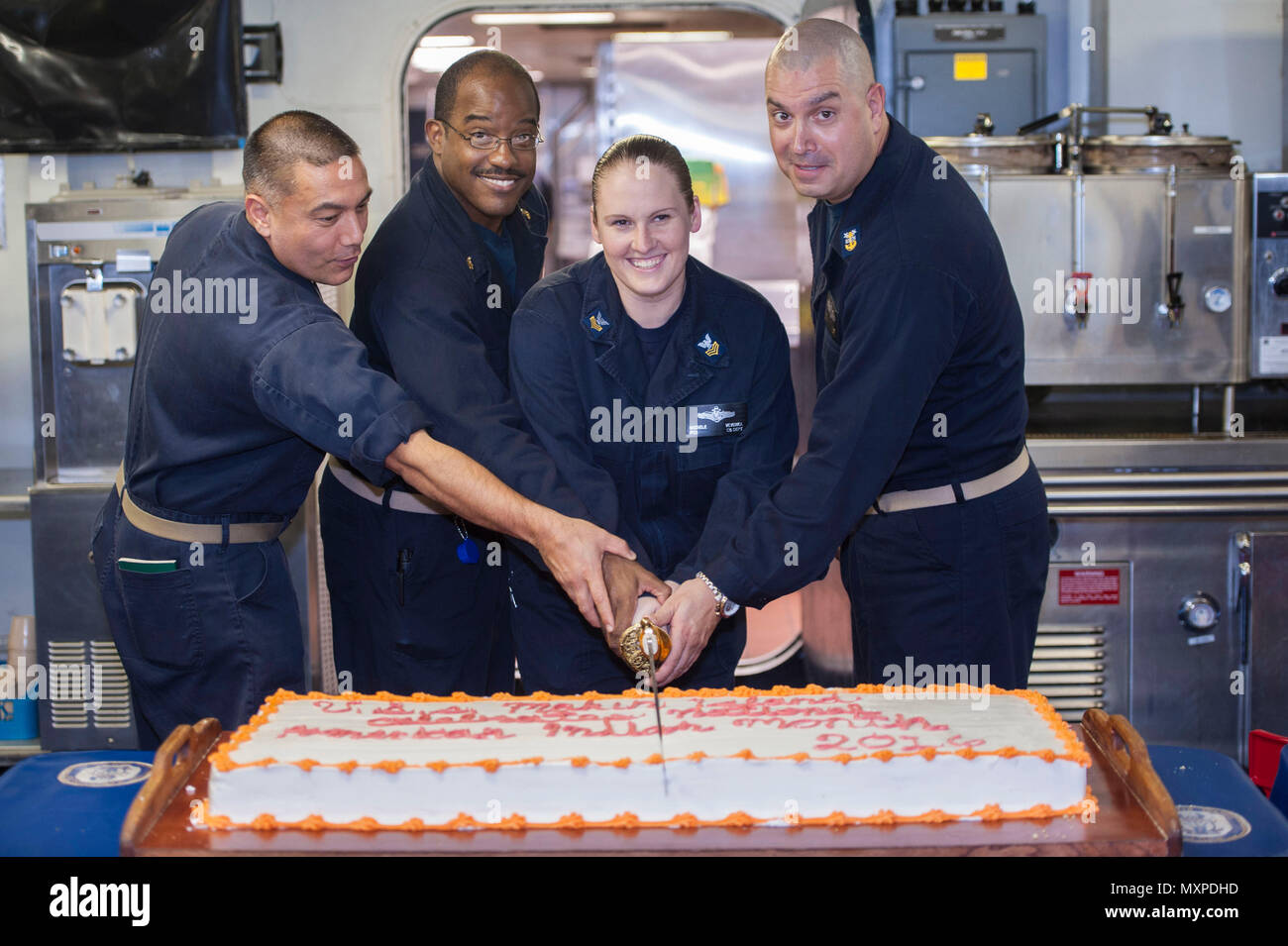 161129-N-EW322-053 OCEANO INDIANO (nov. 29, 2016) da sinistra, Lt. La Cmdr. Aaron Carlton, da Torrance, California, Senior Chief Petty Officer Terrance Ingram, da St. Louis, Sottufficiali di prima classe Veverka Michele, da Phoenix e il comando Master Chief Larry A. Lynch tagliare una fetta di torta nella celebrazione dei Nativi Americani e Alaska patrimonio nativo mese osservanza sul disordine dei ponti a bordo dell'assalto anfibio nave USS Makin Island (LHD 8). Il Dipartimento della Difesa riconosce indiani americani e nativi dell'Alaska durante il mese di novembre per il loro servizio dedicato per entrambi il DOD missione e al nostro cou Foto Stock