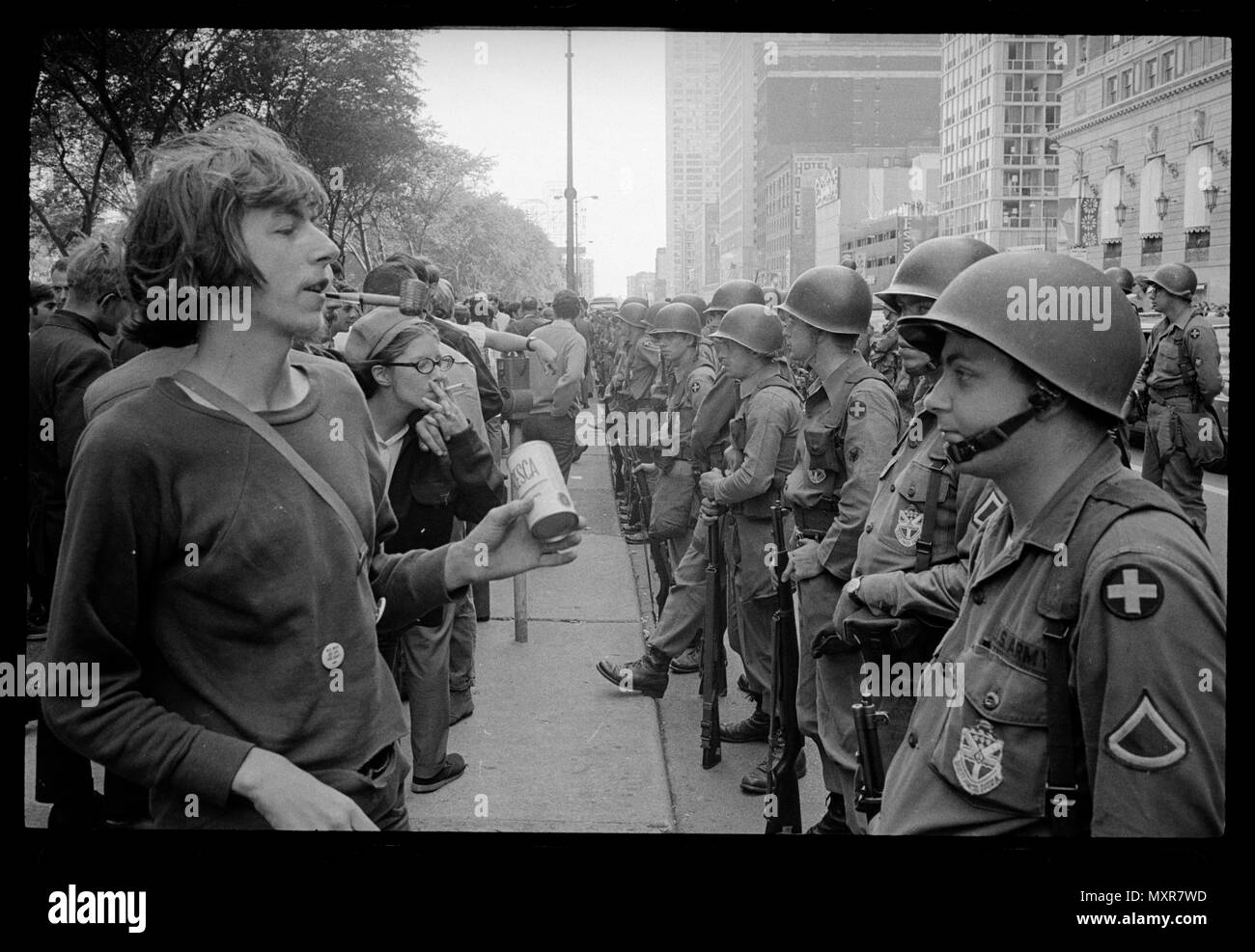 Giovane "hippie' in piedi di fronte a una fila di soldati della guardia nazionale di stanza, attraversata la strada dall'Hotel Hilton al Grant Park, alla Convenzione Nazionale Democratica in Chicago, Agosto 26, 1968, Foto di Warren K. Leffler. Foto Stock