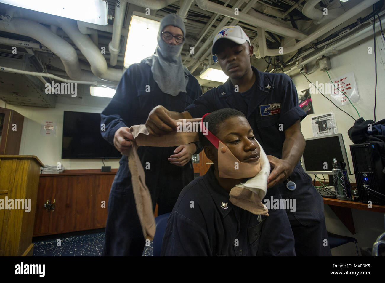 161130-N-WS581-107 U.S. 5TH FLOTTA AREA DI OPERAZIONI (nov. 30, 2016) Petty Officer di terza classe Mustafah Briggs, da Baltimora, destra dimostra di marinaio Hunter Arthur, da Zanesville, Ohio, come ad avvolgere la lacerazione del viso di Sottufficiali 3d classe Tayla Moreland, da Dallas, durante i quartieri generali trapani a bordo guidato-missili cruiser USS San Jacinto (CG 56). San Jacinto, distribuito come parte di Eisenhower Carrier Strike gruppo, è di sostenere le operazioni di sicurezza marittima e di teatro la cooperazione in materia di sicurezza gli sforzi negli Stati Uniti Quinta Flotta area di operazioni. (U.S. Navy foto di Petty Offi Foto Stock