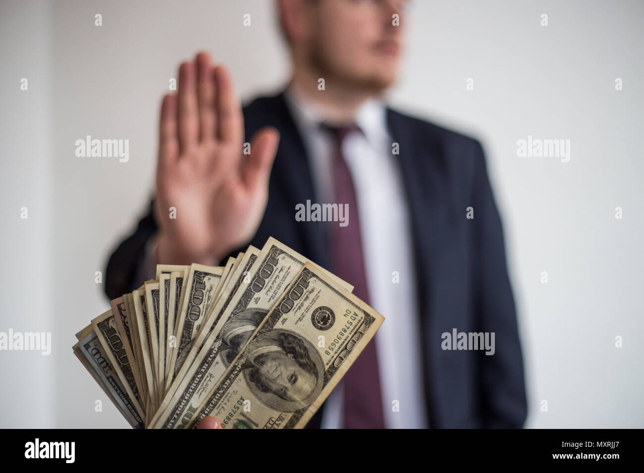 Tangenti e corruzione, offerto denaro per un imprenditore in un vestito, non vuole prendere loro, tenere mani verticale Foto Stock
