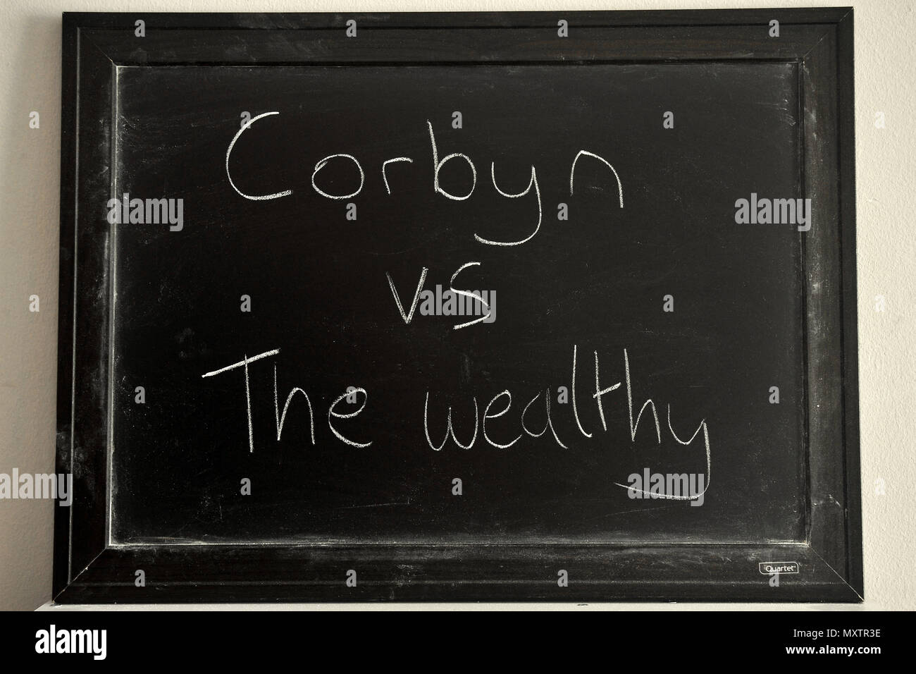 Corbyn vs i ricchi scritto in bianco gesso su una lavagna. Foto Stock