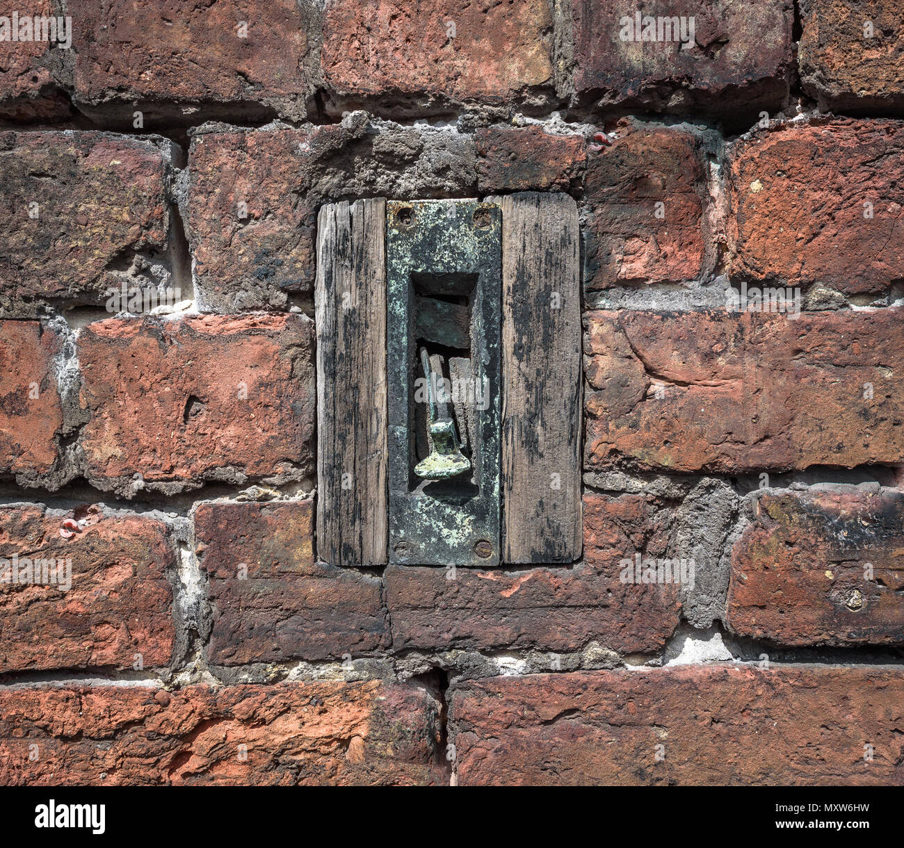 Un vecchio tirare la maniglia del campanello impostato in un muro di mattoni. Foto Stock