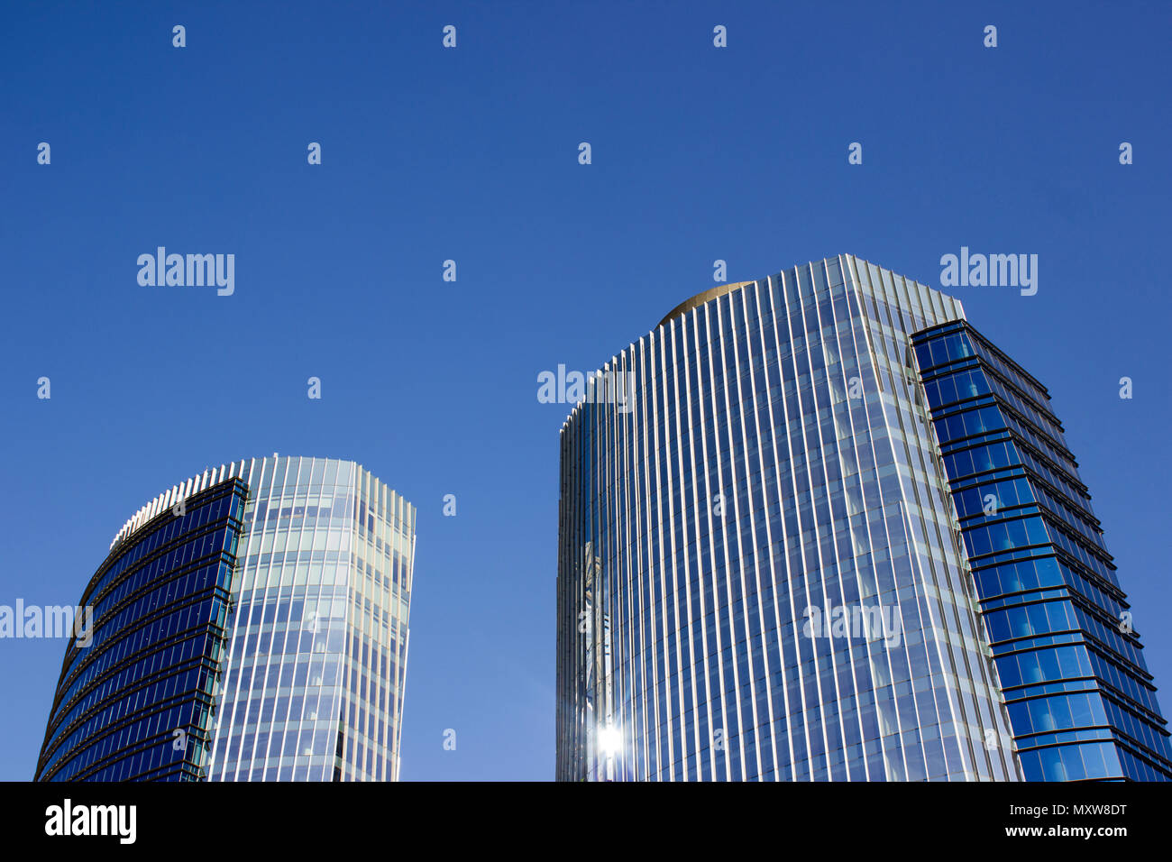 Ripresa a tutto campo di una coppia di gemelli corporate ufficio blu edifici ad alta con un design a strisce. Foto Stock