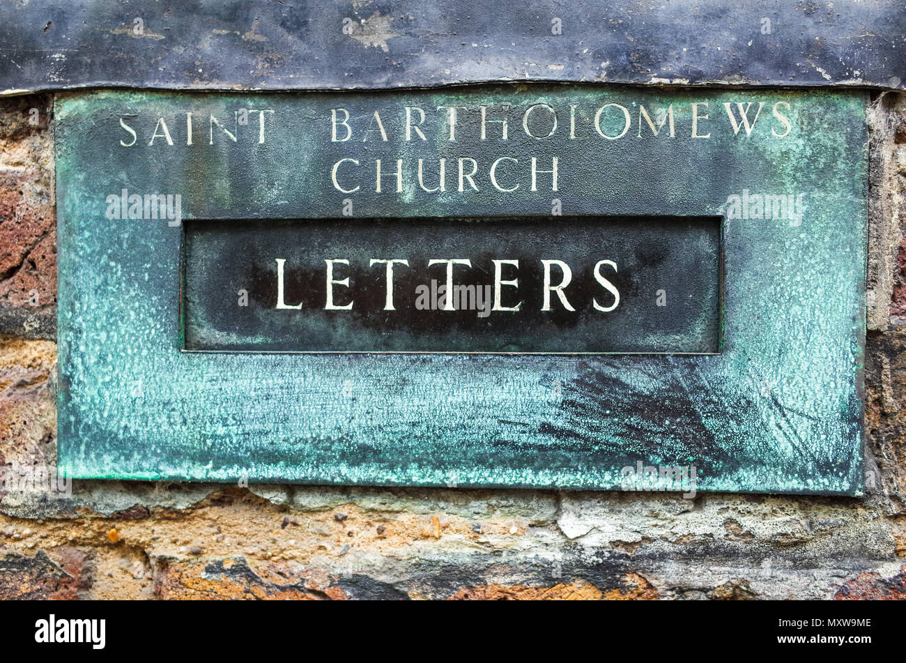 San Bartolomeo la grande chiesa di Londra - weathered letter box. Fondata 1123 la chiesa è stata una località per il film Quattro matrimoni e un funerale Foto Stock