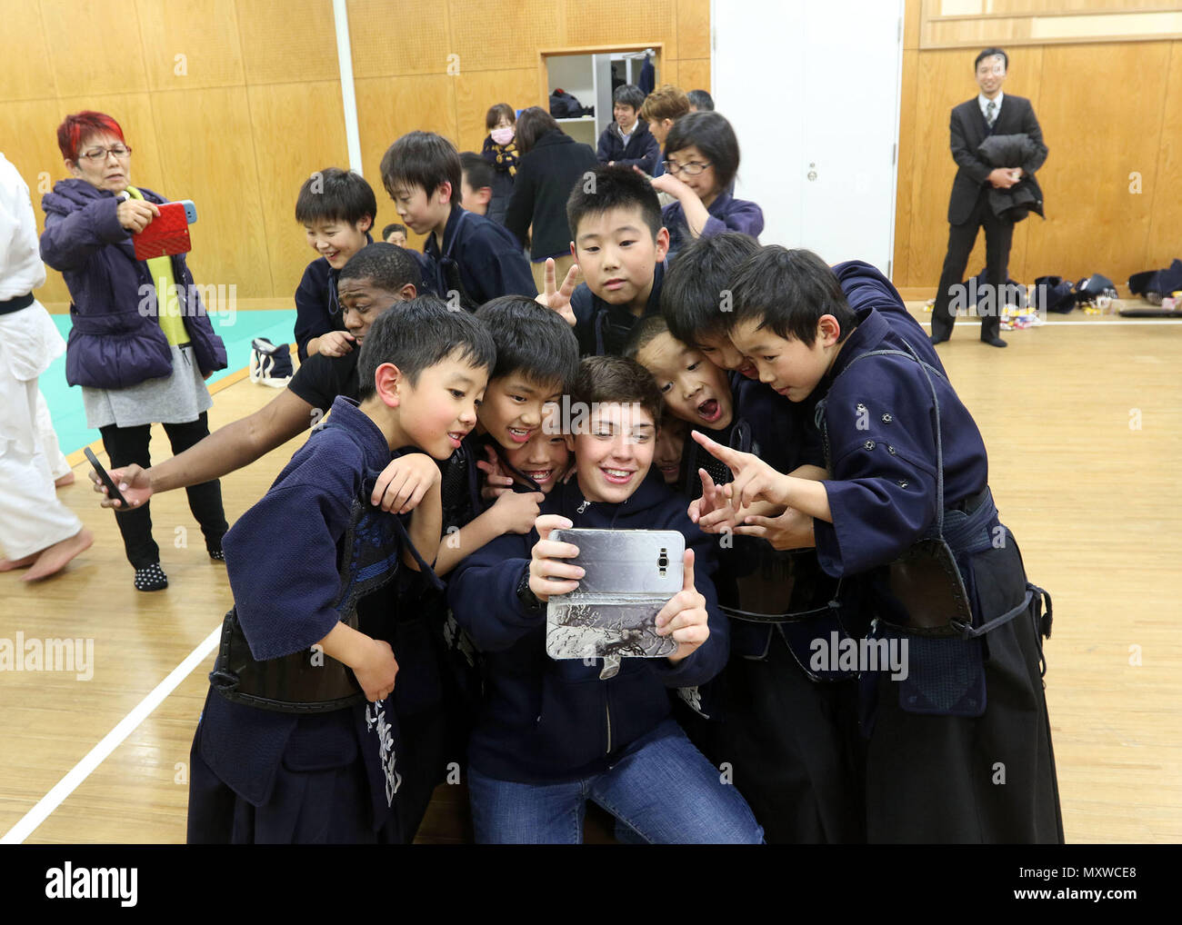 CAMP KENGUN, città di Kumamoto, Prefettura di Kumamoto, Giappone - privato di prima classe Kayla Melton, la polizia militare ufficiale con la 247MP DISTACCO, prende un selfie con i bambini della città di Kumamoto stazione di polizia Kendo dojo. I soldati hanno frequentato corsi di formazione di Kendo presso la città di Kumamoto stazione di polizia per promuovere buone relazioni tra i militari statunitensi e il popolo giapponese durante Yama Sakura 71. Esercizio Yama Sakura 71 è annualmente un posto di comando esercizio co-sponsorizzato da U.S. Pacifico esercito e il JGSDF a Camp Kengun da Dic. 1-13. Lo scopo di questo esercizio è di migliorare negli Stati Uniti e in Giappone il combattimento Foto Stock