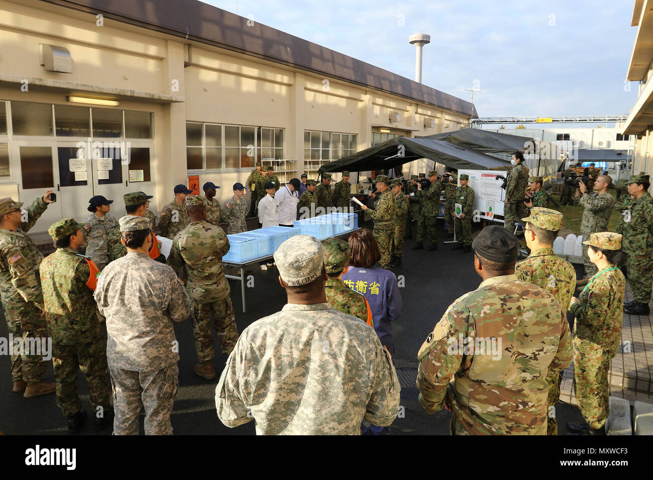 I membri del servizio dell'U.S. Esercito e Giappone terra Forza di Autodifesa si radunano insieme per incitare i loro team a competere in Yama Sakura 71 Iron Chef battaglia posano per una foto di gruppo su Camp Kengun, Giappone, Dicembre 5, 2016. Foto Stock