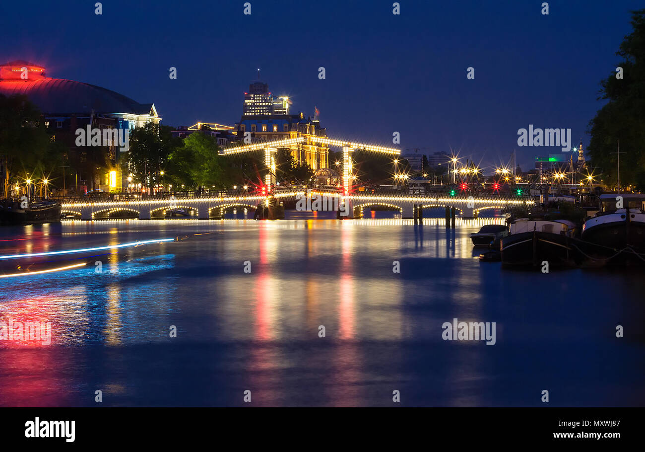 Il magro ponte Magere Brug di notte, Amsterdam, Olanda, l'Europa. Foto Stock