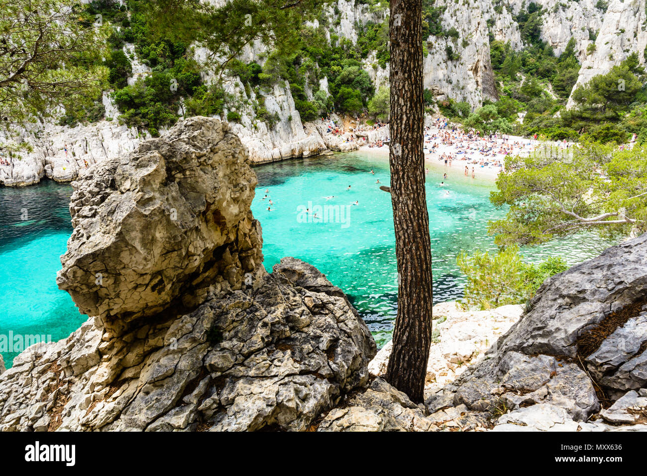 Vista di calanque En-Vau, una insenatura naturale con acqua limpida e spiaggia di sabbia bianca nei pressi di Marsiglia e Cassis, con la gente a prendere il sole e nuotare Foto Stock