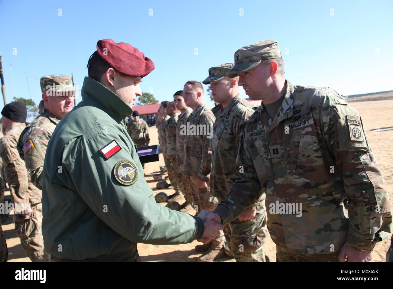 Polonia Il Mag. Zbigniew Sarnowski, vice comandante del XXV aria brigata di cavalleria, scuote le mani con il cap. Ian McKnight, 1-325 Airborne Reggimento di Fanteria, 2° Brigata, ottantaduesima Airborne Division, dopo avergli è la Polonia jump ali durante una operazione di aerei per il XIX annuale di Randy Oler Memorial il funzionamento del giocattolo Drop, ospitato dalla U.S. Esercito degli affari civili e le operazioni psicologiche il comando (airborne), a Luzon nella zona di caduta, N.C., Dicembre 9, 2016. Il funzionamento del giocattolo Drop è la più grande del mondo di combinata airborne funzionamento e formazione collettiva con otto partner-nazione paracadutisti che partecipano. (U.S. Esercito Ph Foto Stock