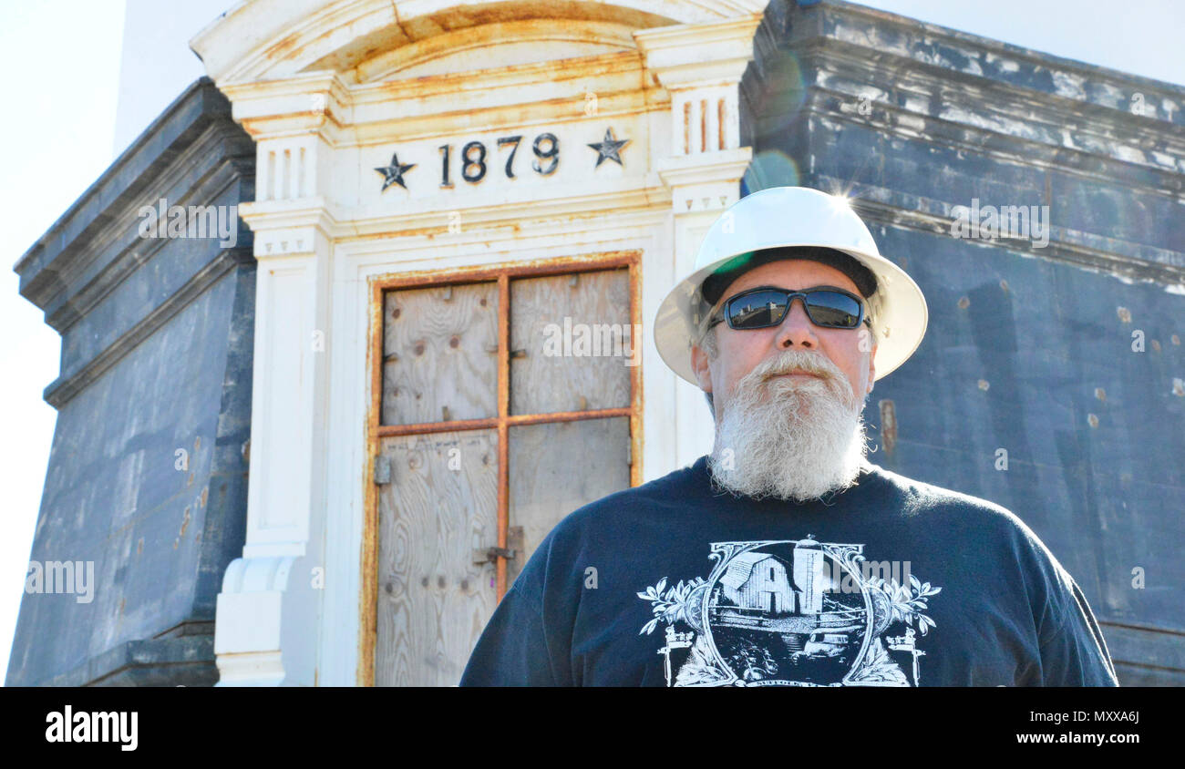 La guardia costiera della rappresentante di costruzione Herky Matthews sta davanti al nuovo Cape Henry Lighthouse in Virginia Beach, Virginia, nov. 18, 2016. Matthews ha supervisionato la conservazione poiché è iniziato nel maggio 2016. (U.S. Coast Guard foto di Sottufficiali di seconda classe Nate Littlejohn) Foto Stock