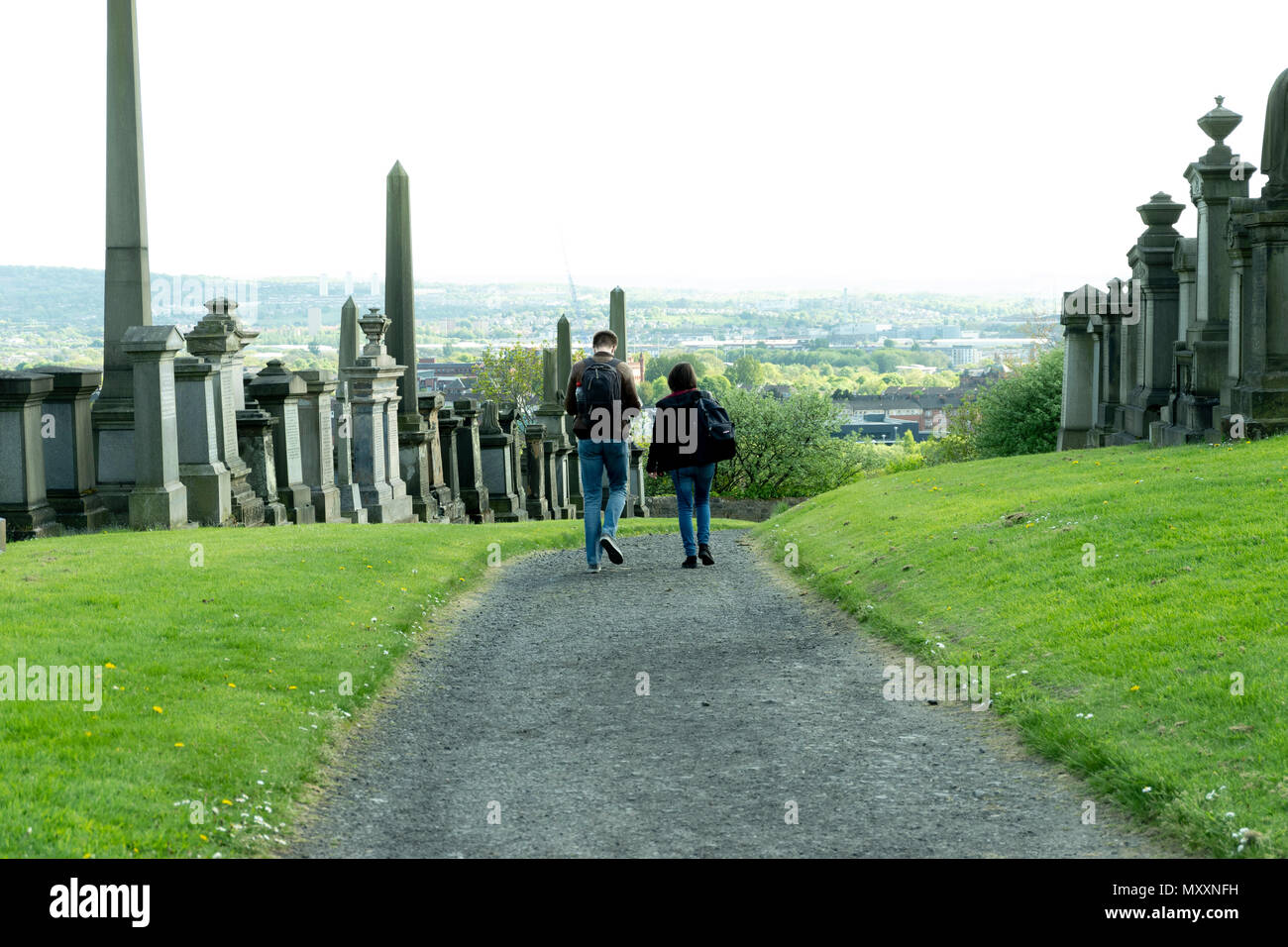 Uomo e donna vanno attraverso la necropoli di Glasgow, Scozia Foto Stock