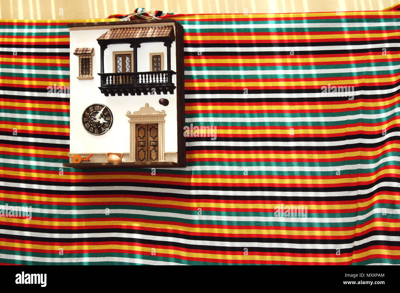 Immagine colorata con una facciata di una tradizionale casa in miniatura appeso alla parete con un panno sotto Foto Stock
