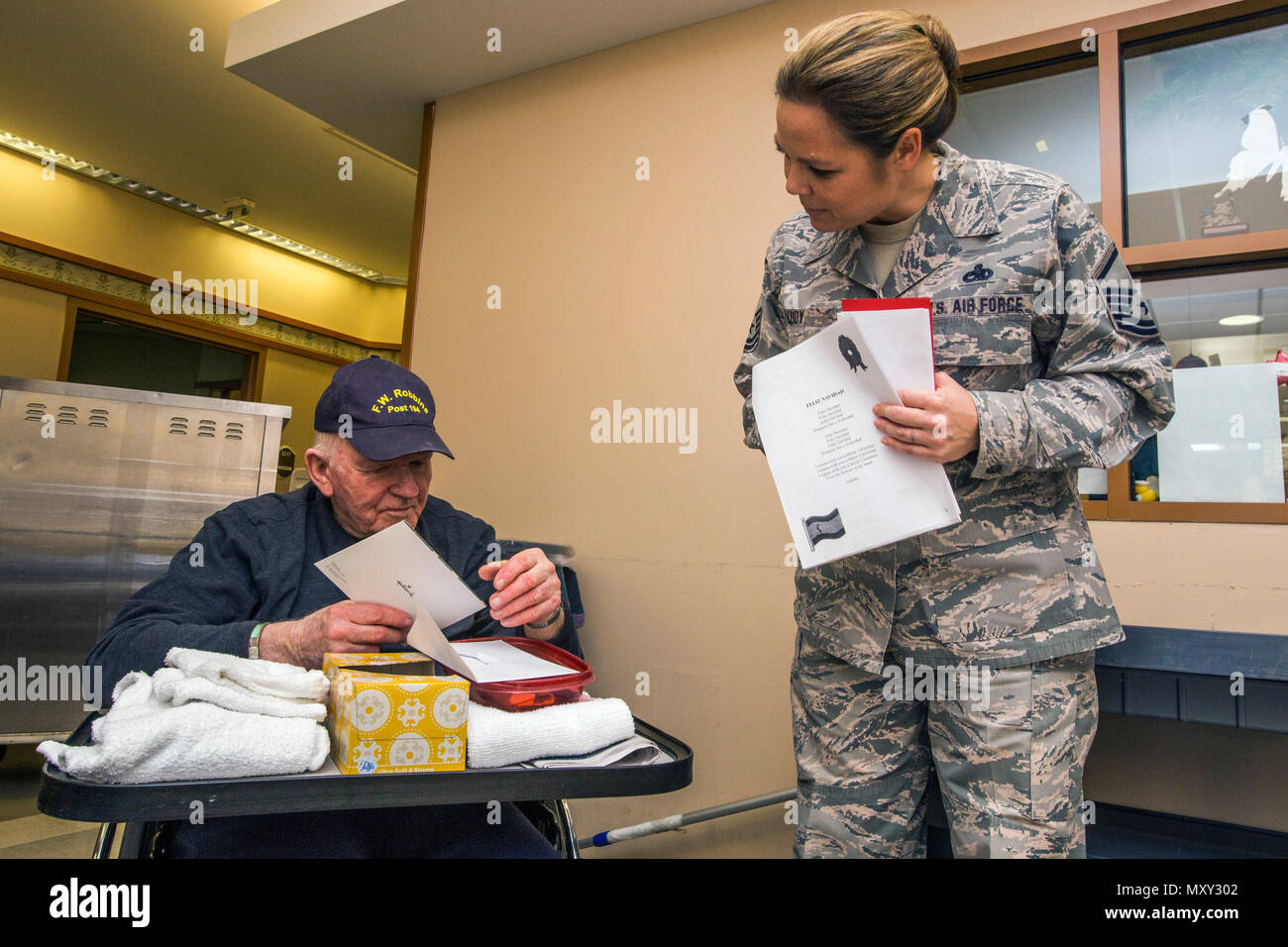 Master Sgt. Jamie Ludy, destra, 177th squadrone di manutenzione dà la Marina Coreana veterano di guerra Richard Ellis una carta durante il XVI vacanza annuale "ongfest' presso il New Jersey Veterans Memorial Home a Vineland, N.J., Dic 13, 2016. Più di 80 quarta livellatrici dal Seaview Scuola Elementare di Linwood, N.J., e 18 aviatori cantato canzoni di vacanza e distribuite le carte per la casa residenti durante l'evento. (U.S. Air National Guard foto di Master Sgt. Riferimento C. Olsen/rilasciato) Foto Stock