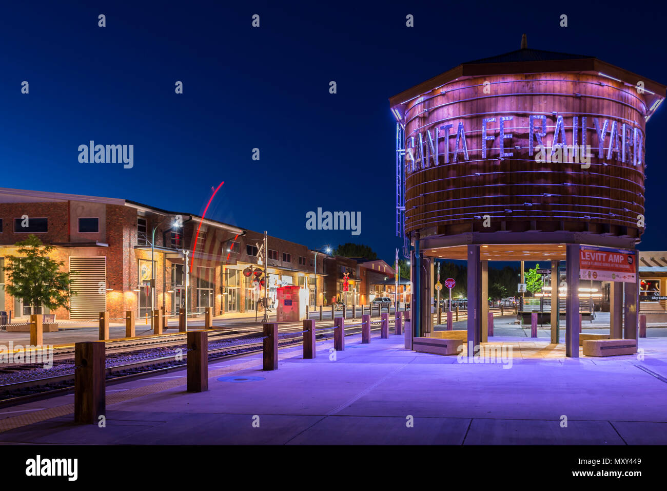 Santa Fe Railyard e water tower illuminata di notte, con attraversamento ferroviario gates scendendo nel Nuovo Messico, Stati Uniti d'America. Foto Stock