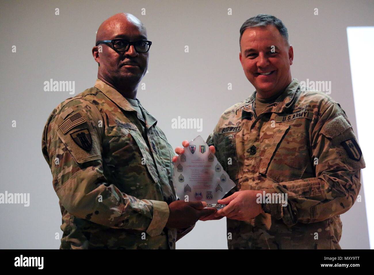 Il comando Sgt. Il Mag. Stephen M. Bodwell, 368 Eng. Bn. presenta il comando Sgt. Il Mag. Anthony Simms con un battaglione premio come un segno di apprezzamento per le sue parole di incoraggiamento alla Task Force soldati di granito che partecipano al funzionario Non-Commissioned induzione cerimonia tenutasi a Camp Arifjan, Kuwait, nov. 29, 2016. La cerimonia consisteva di circa 106 soldati da 312Eng. Co, 389a Eng. Co., 461st Eng. Co, 475th Eng. Co., sede e Sede Co. e supporto in avanti Co. di 368 Eng. Bn. (U.S. Foto dell'esercito da Capt. Maria Mengrone/rilasciato) Foto Stock