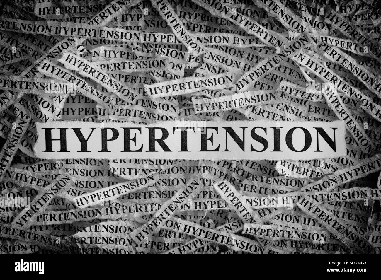 Ipertensione. Pezzi di carta strappati con le parole di ipertensione. Concetto di immagine. In bianco e nero. Primo piano. Foto Stock