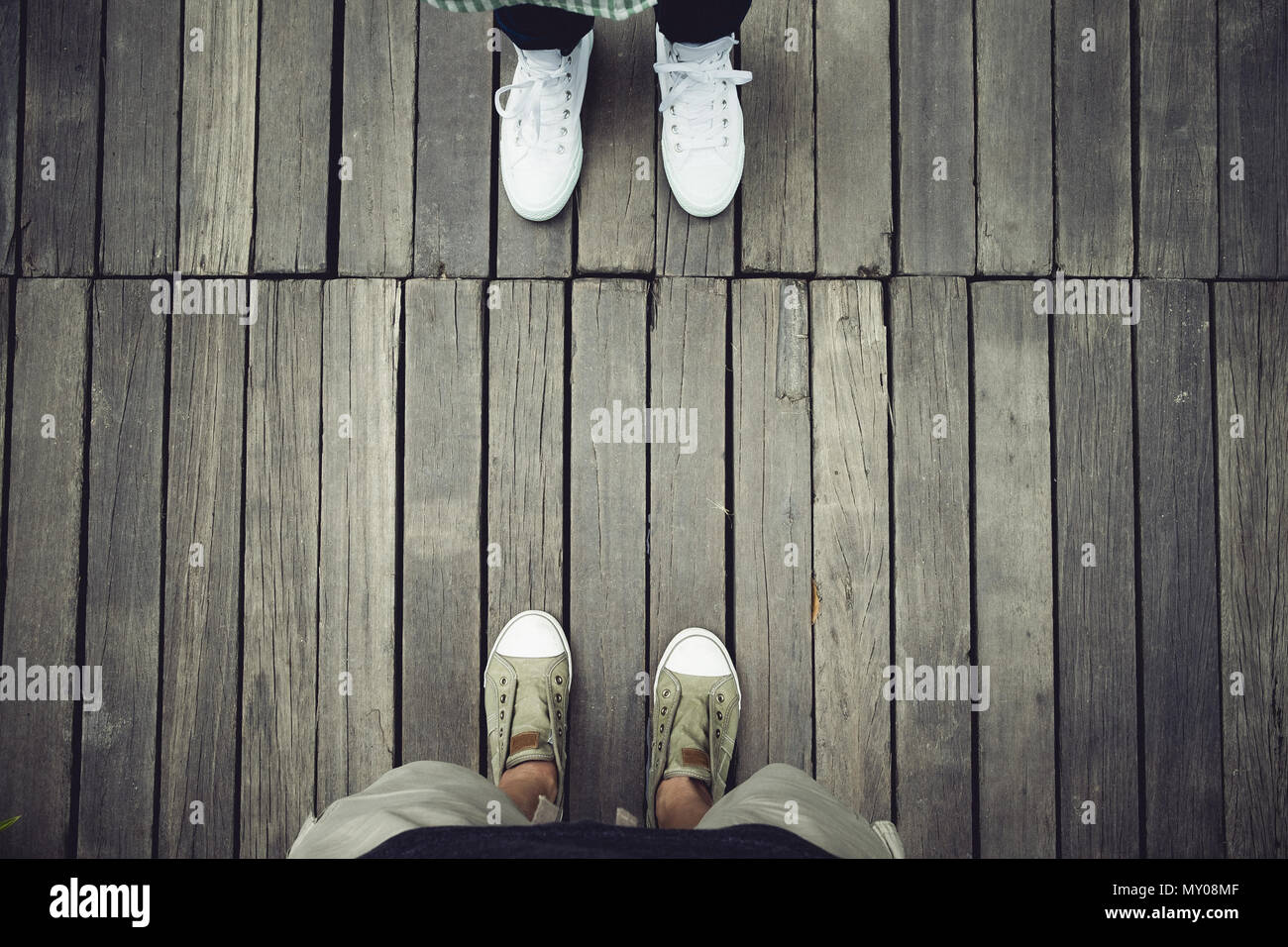 Vista aerea di due persone in piedi di fronte sul legno vecchio pavimento.Lasciare spazio sulla parte superiore per aggiungere il vostro testo Foto Stock