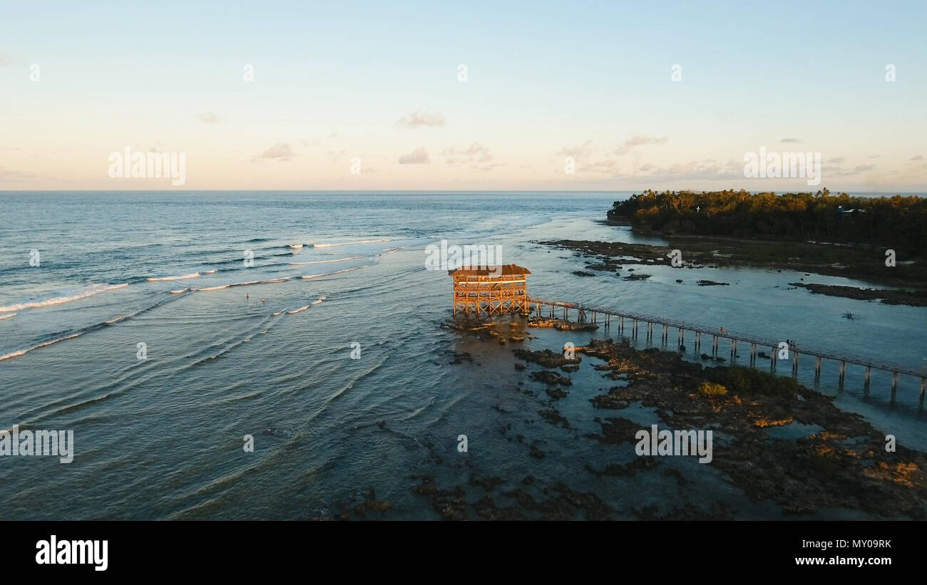 Punto di vista nell'oceano al Cloud Nine surf point, Siargao island , Filippine. Vista aerea sollevata passerella in legno per surfisti di attraversare la barriera corallina di siargao island al cloud 9 surf break sull isola di Mindanao. Isole Siargao famoso surf break cloud 9. Volare sopra il mare blu nelle acque azzurre della laguna. Foto Stock