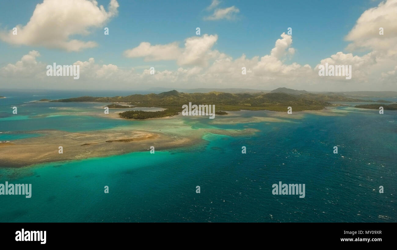 Vista aerea: spiaggia, isola tropicale, Baia Mare e laguna, Siargao. Paesaggio tropicale hill, nuvole e montagne rocce con la foresta pluviale. Acque azzurre della laguna. Paesaggio Shore Bay. Video dell'antenna.Seascape. Foto Stock