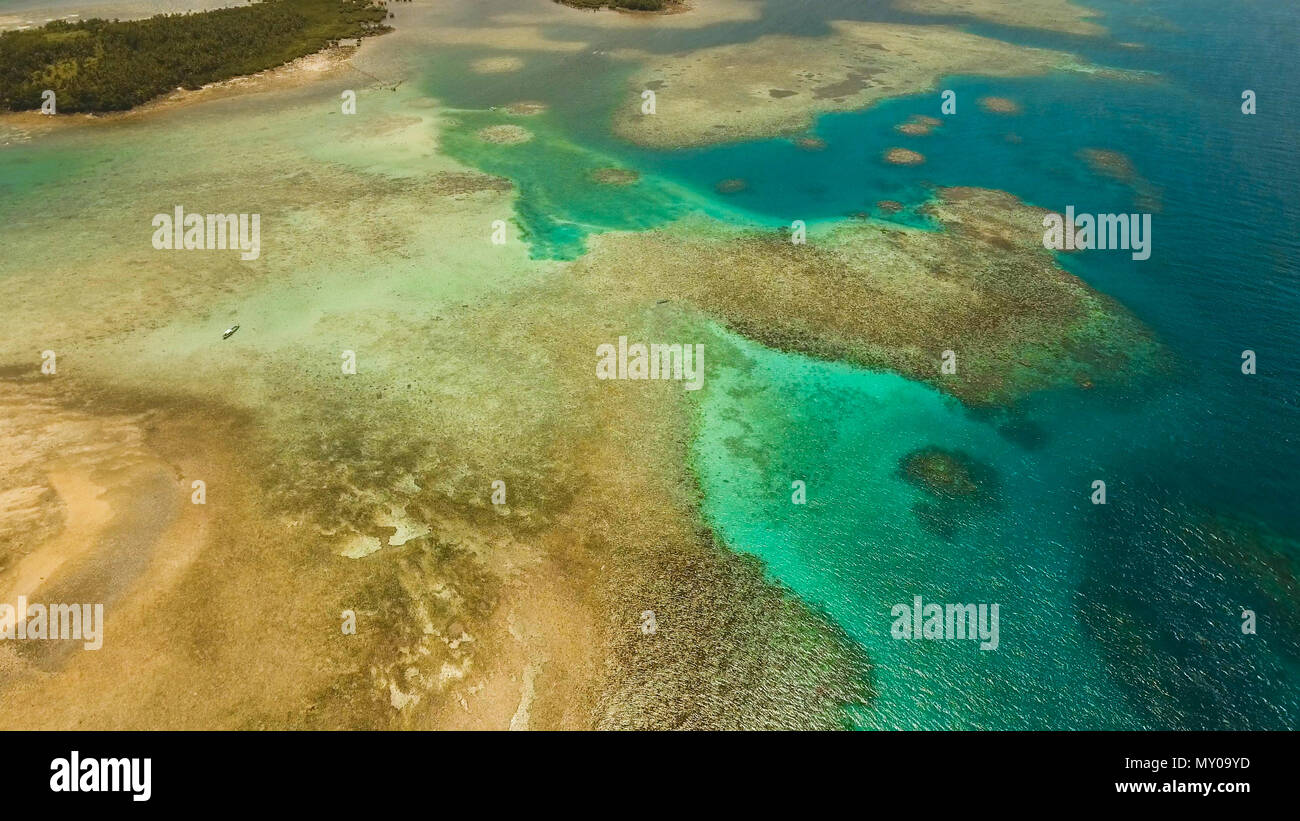 Vista aerea: spiaggia, isola tropicale, Baia Mare e laguna, Siargao. Paesaggio tropicale hill, nuvole e montagne rocce con la foresta pluviale. Acque azzurre della laguna. Paesaggio Shore Bay. Video dell'antenna.Seascape. Foto Stock