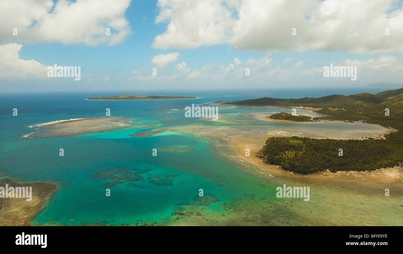 Vista aerea: spiaggia, isola tropicale, Baia Mare e laguna, Siargao. Paesaggio tropicale hill, nuvole e montagne rocce con la foresta pluviale. Acque azzurre della laguna. Paesaggio Shore Bay. Video dell'antenna.Seascape. Foto Stock