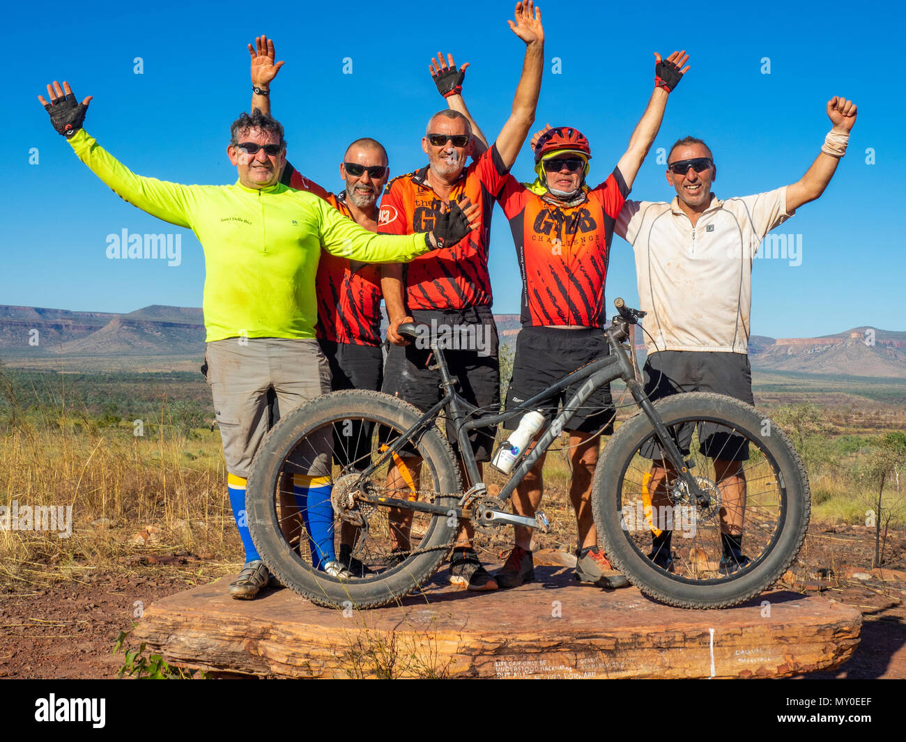 Cinque i ciclisti sulla Gibb Challenege 2018 con un fatbike celebrando a Cockburn varia lookout, Kimberley, WA, Australia. Foto Stock