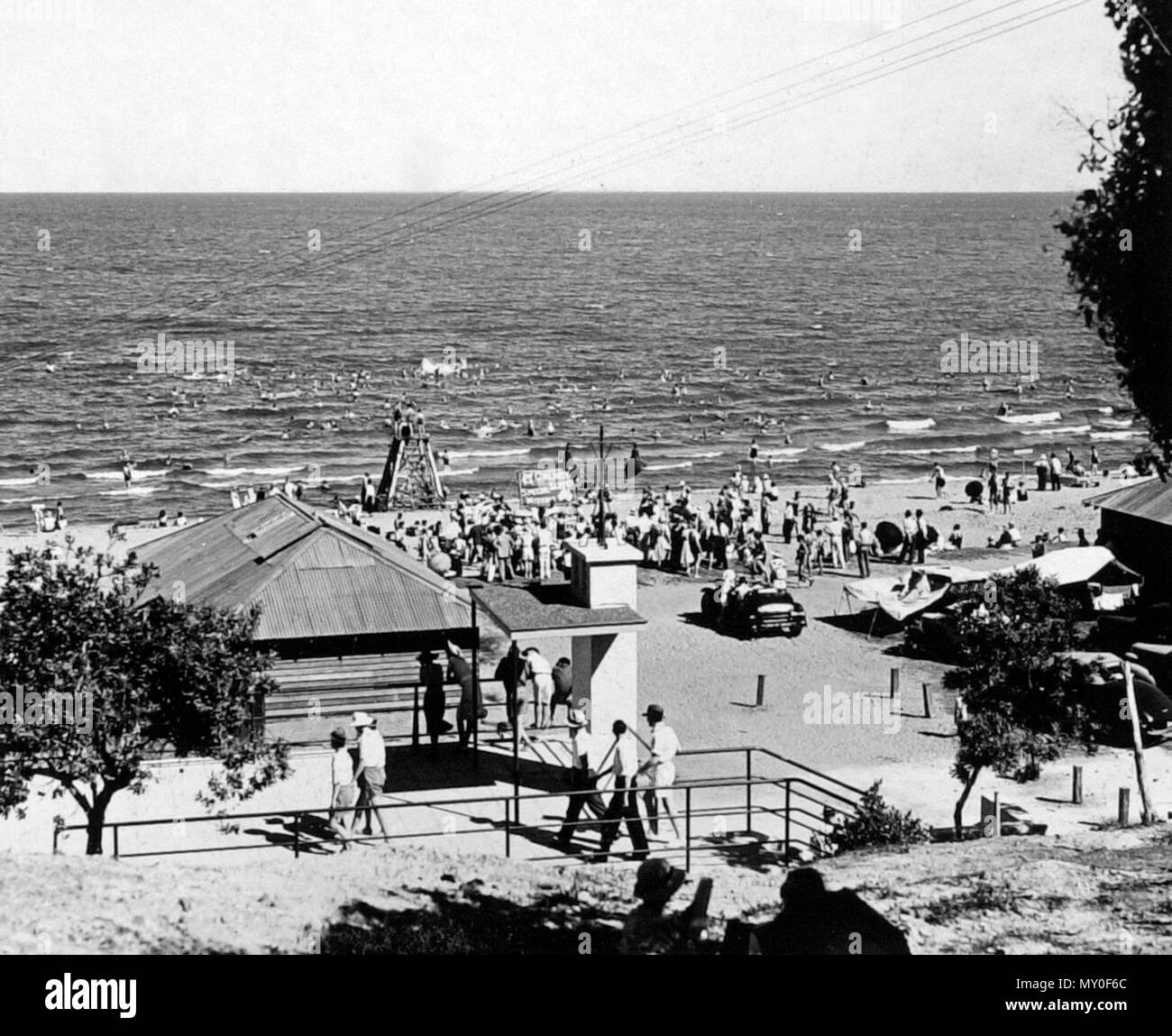 Il padiglione e i bagnanti, Redcliffe, dicembre 1937. Redcliffe mantiene la distinzione di essere il primo insediamento europeo nel Queensland, visitato per la prima volta da Matthew Flinders il 17 luglio 1799. Egli ha rinchiuso il nome Red Cliffe punto dopo il colore rosso scogliere visibili dalla baia ora chiamato punto di Woody. Explorer John Oxley raccomandato Red Cliff punto al Governatore Thomas Brisbane per la nuova colonia, segnalato che le navi che potrebbe atterrare in qualsiasi di marea e ottenere facilmente vicino alla riva.La parte costante in Redcliffe il 13 settembre 1824, sotto il comando del Tenente Henry Miller con 14 soldati, alcuni Foto Stock
