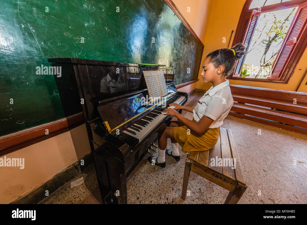 Studente pratica di pianoforte nel centro Escolar a Nueva Gerona su Isla de la Juventud, Cuba Foto Stock
